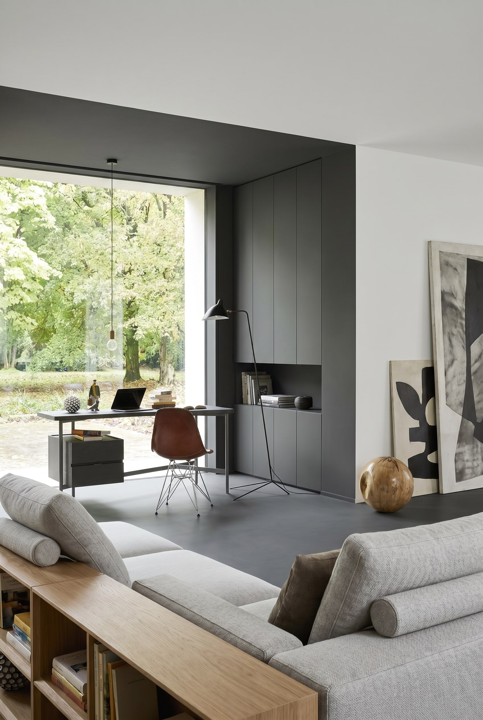 Salon monochrome avec bureau gris clair et chaise en cuir marron
