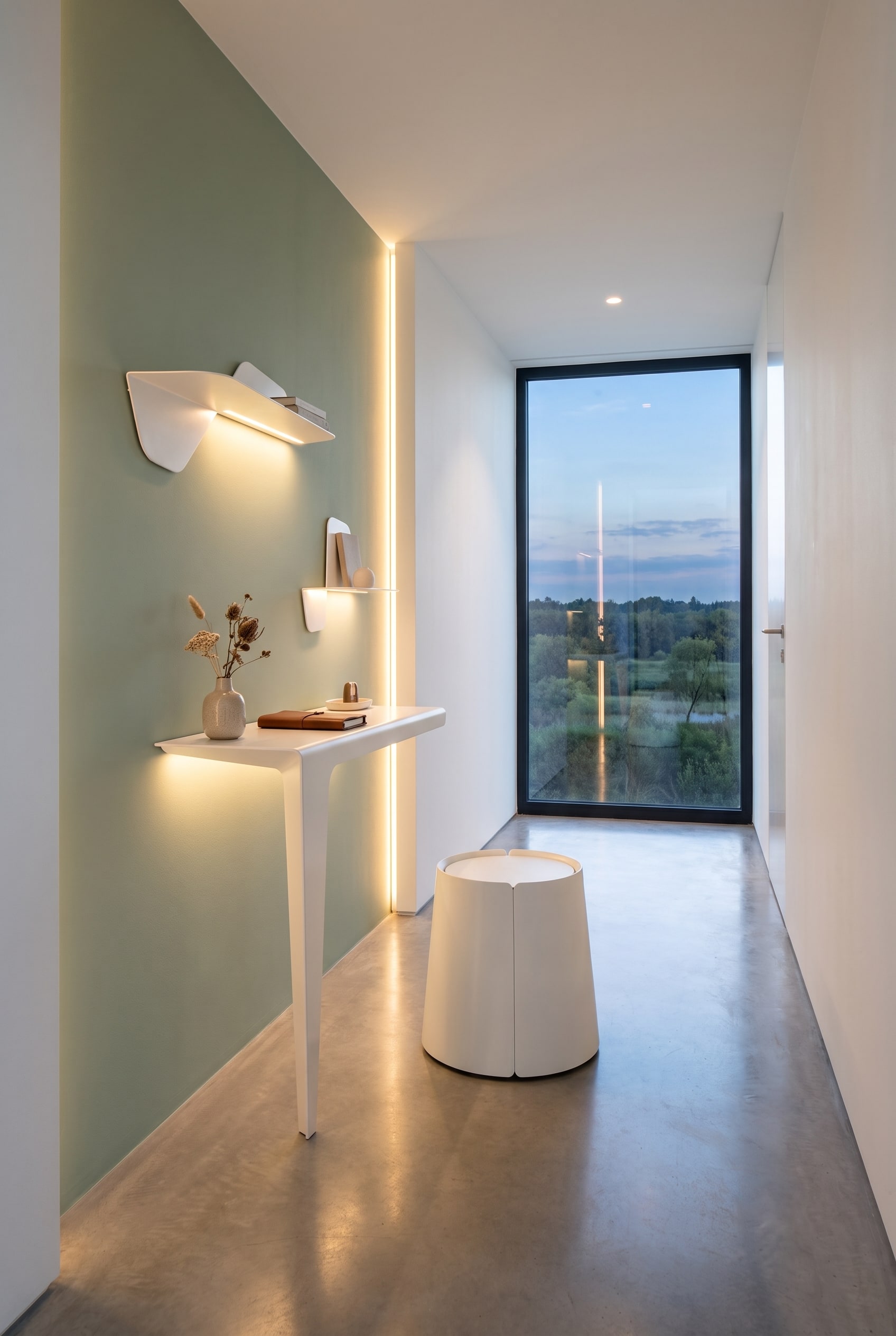 Couloir large avec une niche de couleur contrastée, contenant un bureau délicat aux bords arrondis