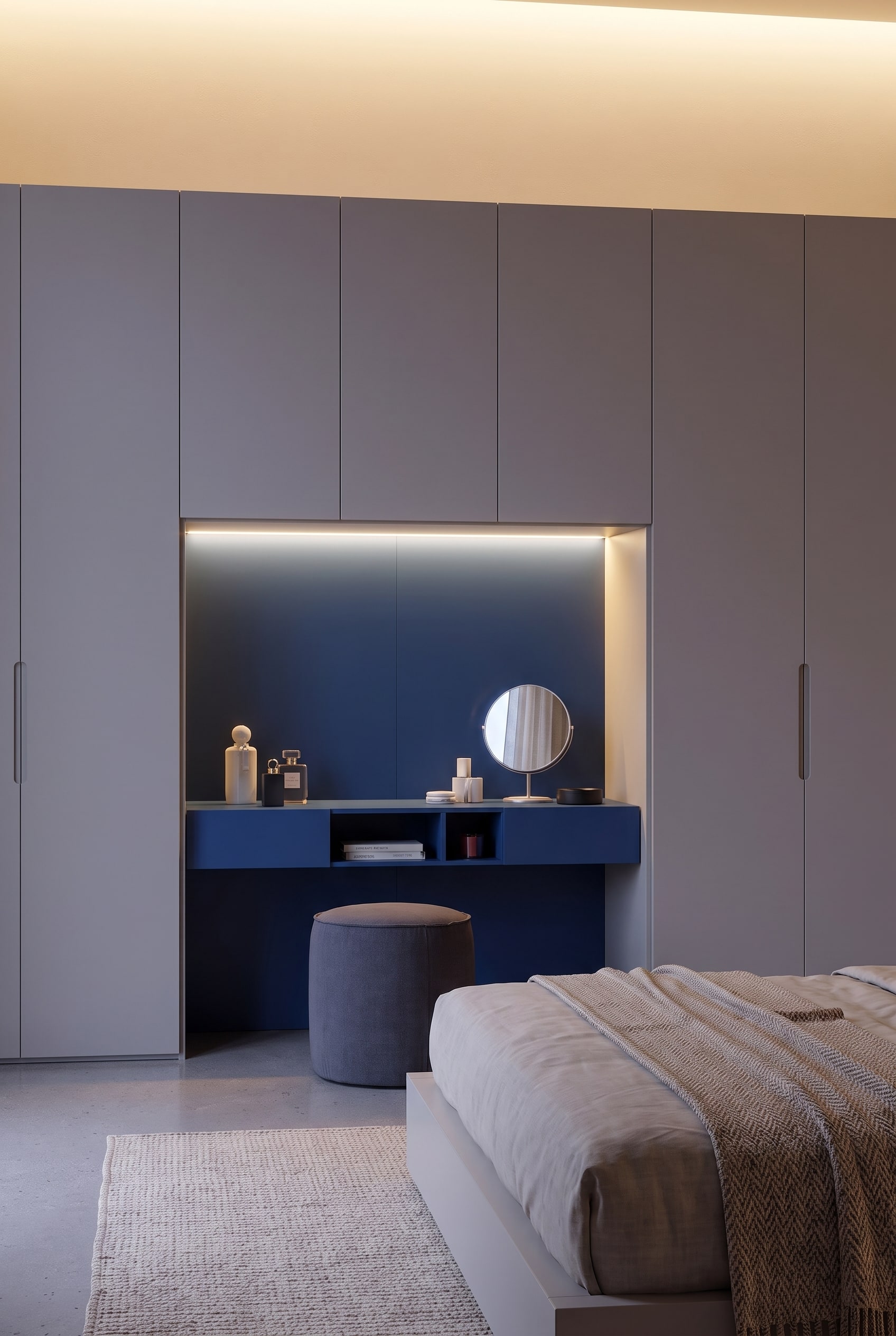 Vue frontale de la niche de maquillage bleu nuit encadrée par des portes d'armoire grège.