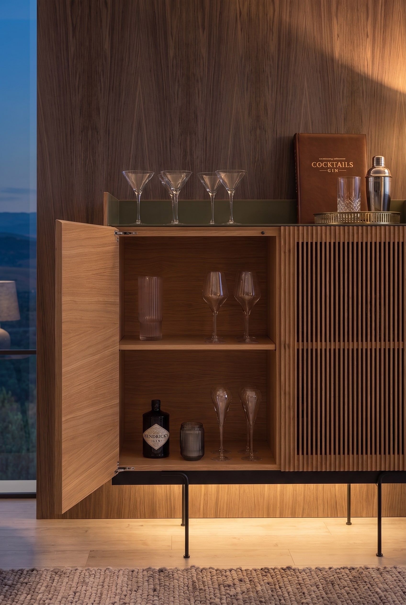 Ge&ouml;ffnetes Highboard aus Eiche mit einger&auml;umten Spirituosen und Gl&auml;sern, beleuchtet durch warmes LED-Licht.
