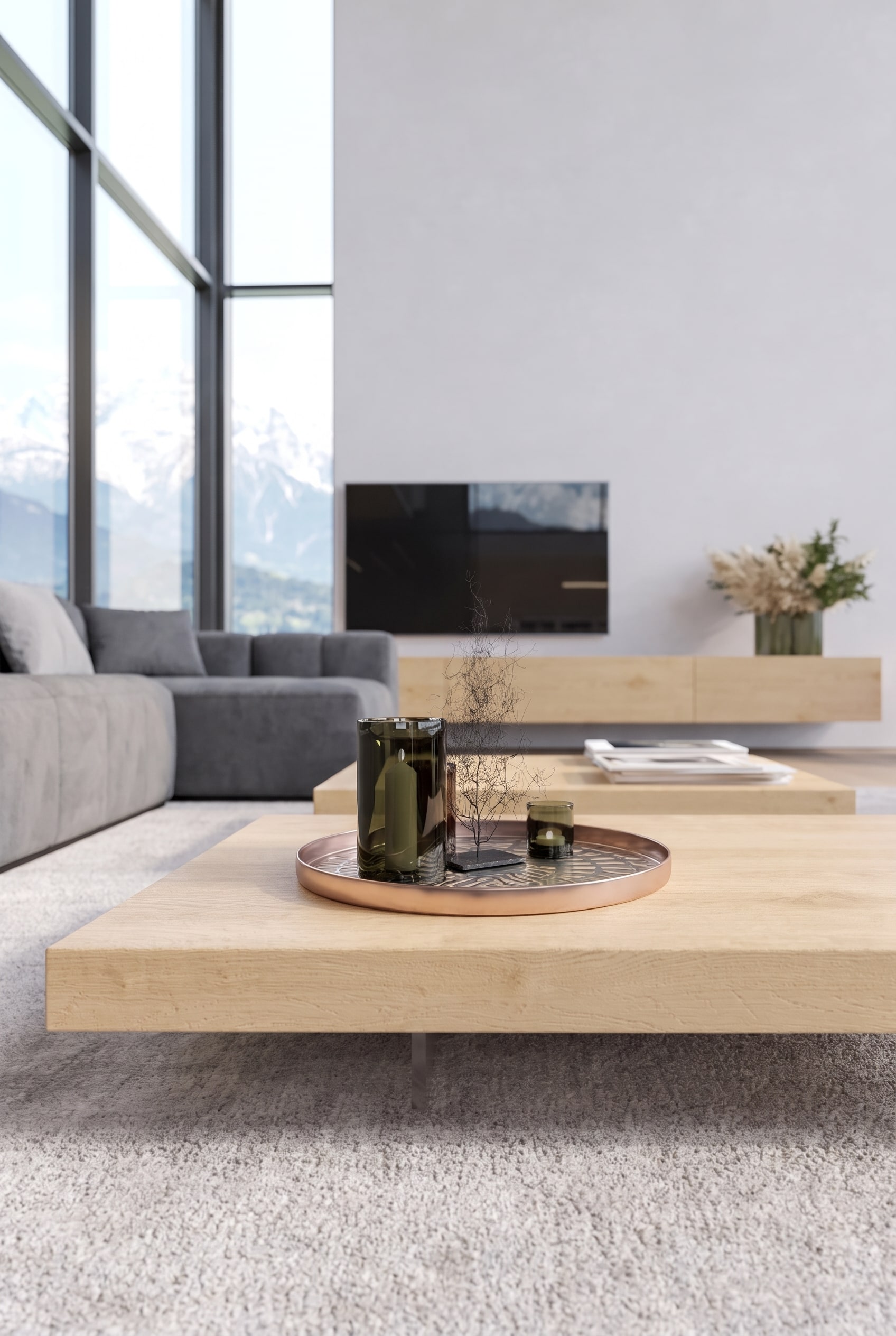 Salon minimaliste avec une table basse en ch&ecirc;ne tr&egrave;s plate, sur laquelle se trouvent uniquement un vase en verre vert fonc&eacute; et un plateau en cuivre