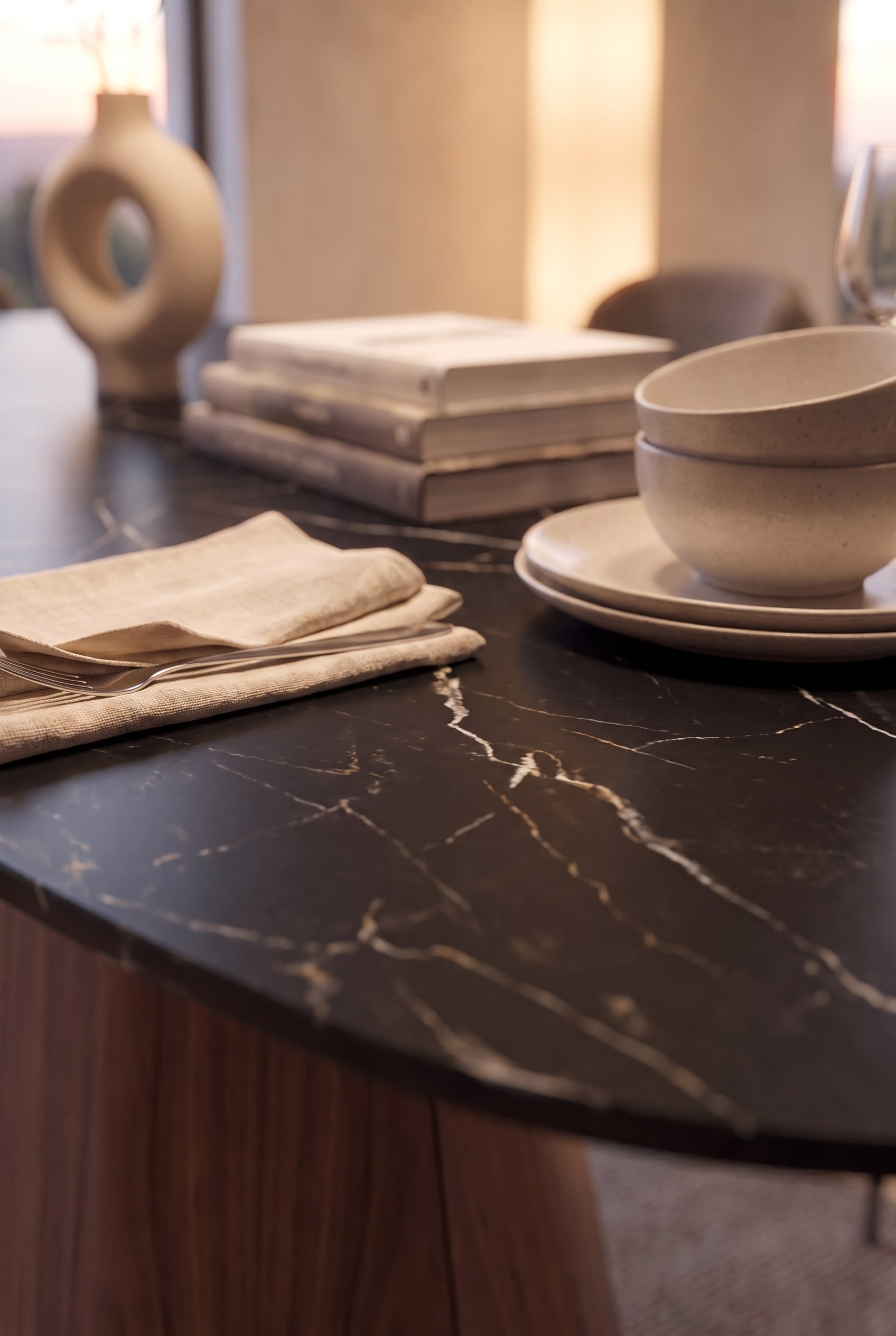 Gros plan du plateau en céramique Marquina noir avec des veines blanches marquées et de la vaisselle claire.