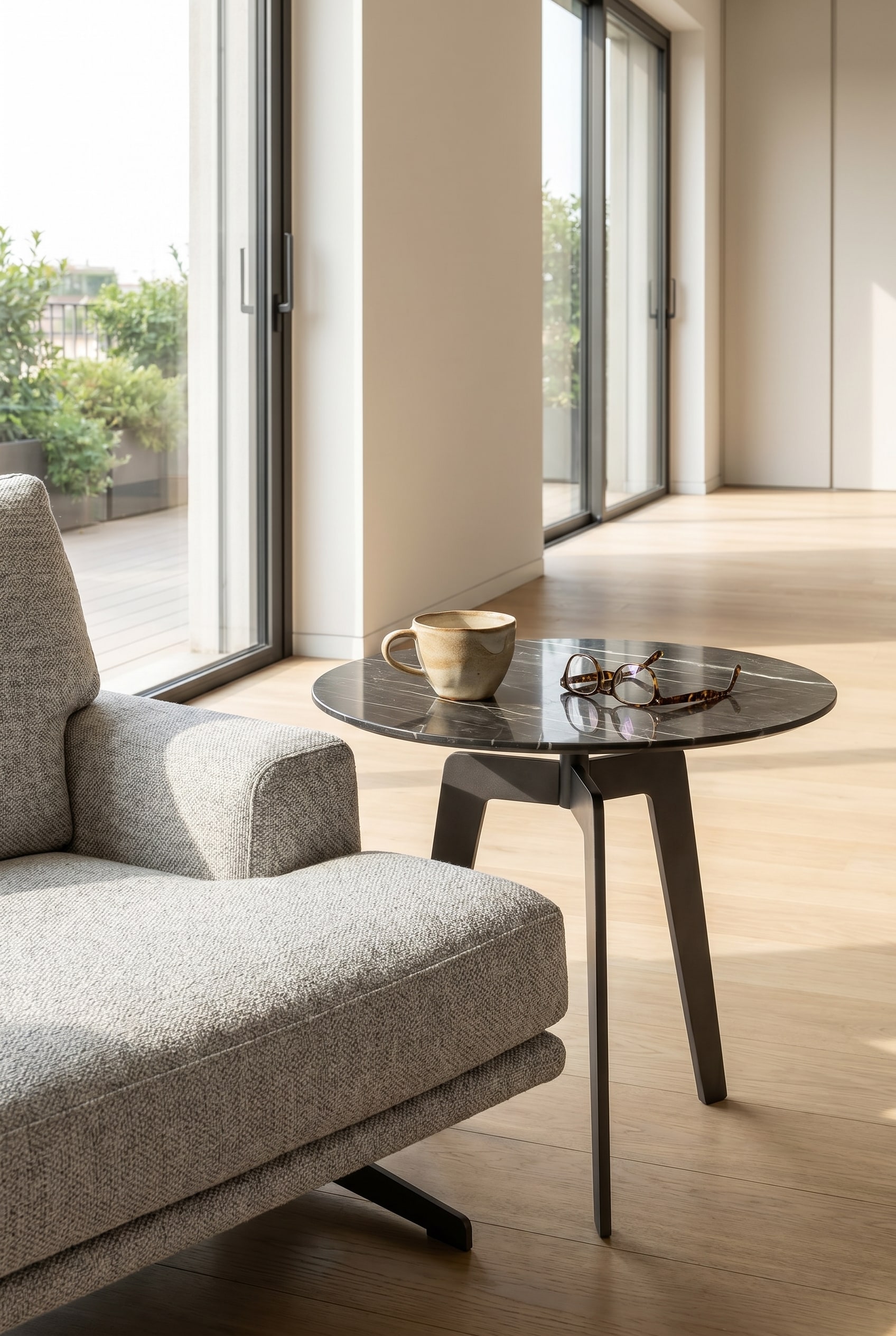 Table d'appoint minimaliste Lotus aspect marbre à côté d'un fauteuil lounge avec une tasse de café blanche