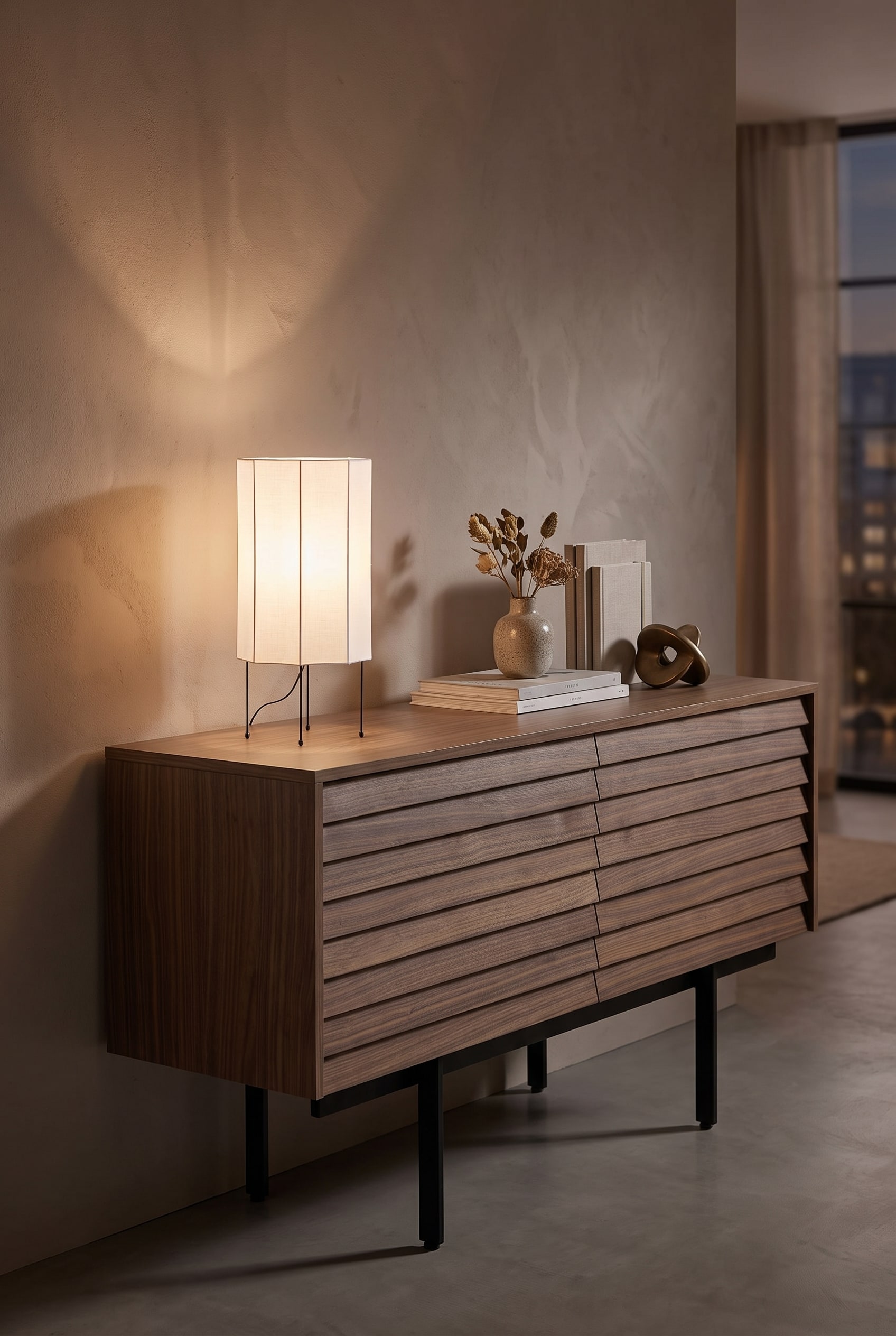 Vue détaillée d'une lampe de table puriste avec un abat-jour en textile clair sur une console en noyer foncé, sous une lumière chaude