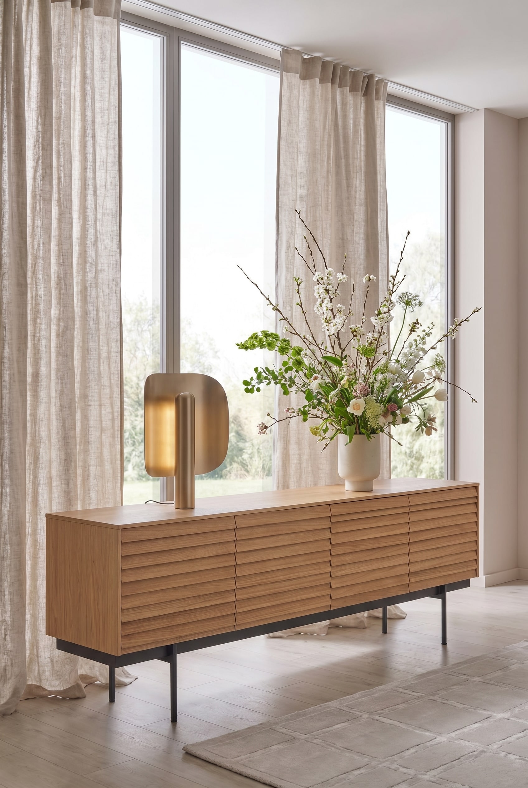 Salon minimaliste avec un buffet à lattes de bois, surmonté d'un grand bouquet de printemps asymétrique Salon minimaliste avec un buffet à lattes de bois, surmonté d'un grand bouquet de printemps asymétrique