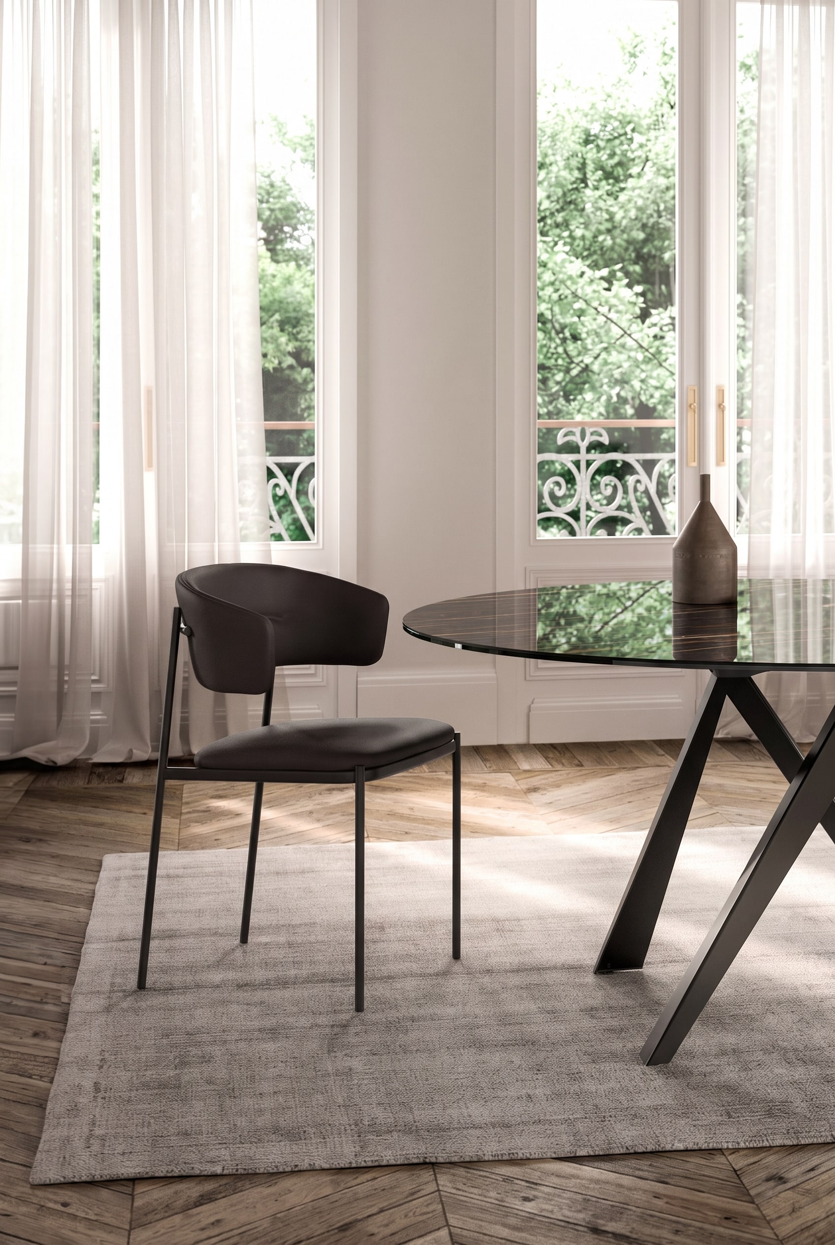 Helles Esszimmer mit dunklem Glas-Esstisch und einem dunklen, gepolsterten Esszimmerstuhl mit filigranem Metallgestell.