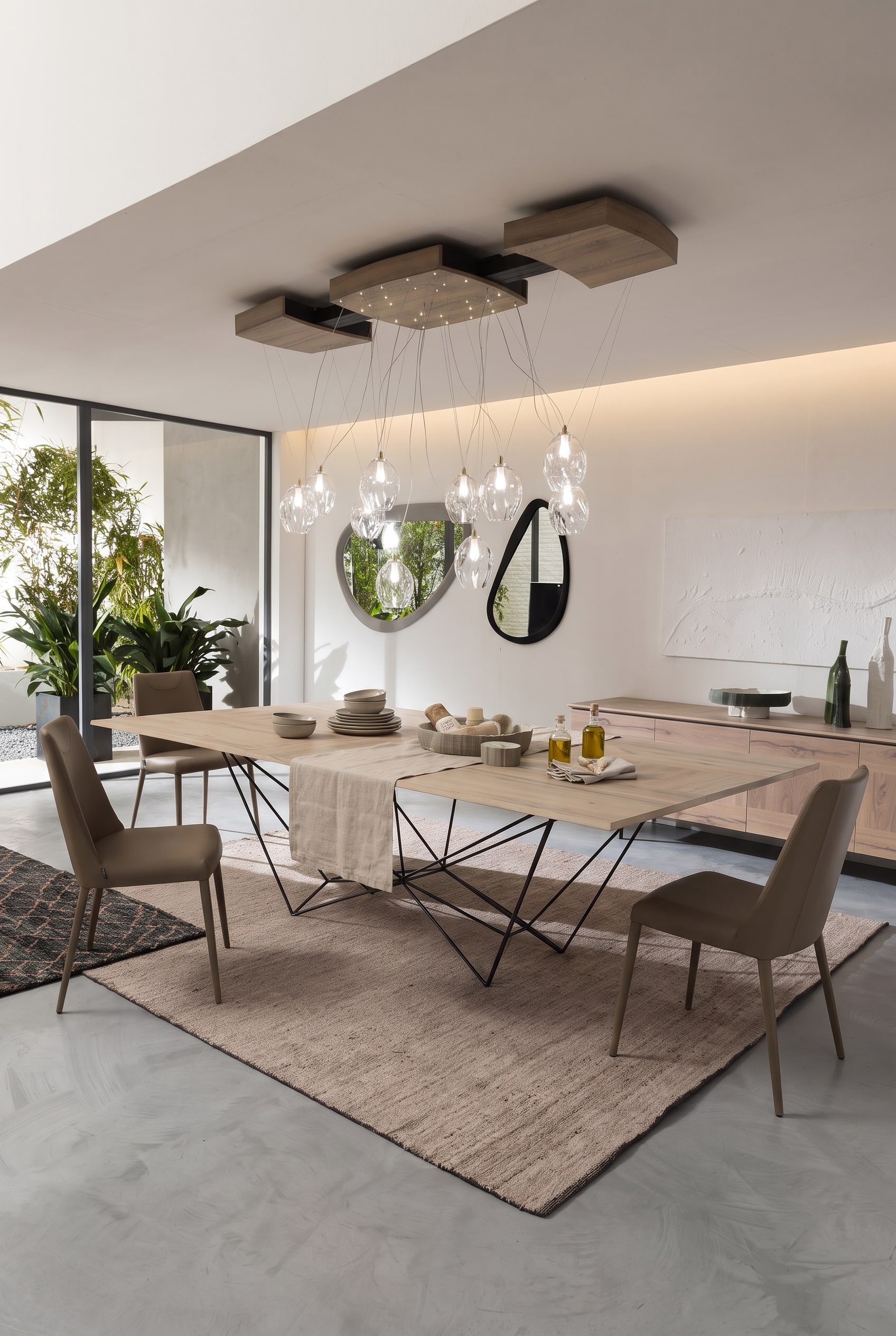 Salle &agrave; manger moderne avec table en bois extensible, pi&egrave;tement en m&eacute;tal noir et &eacute;l&eacute;gantes chaises en cuir