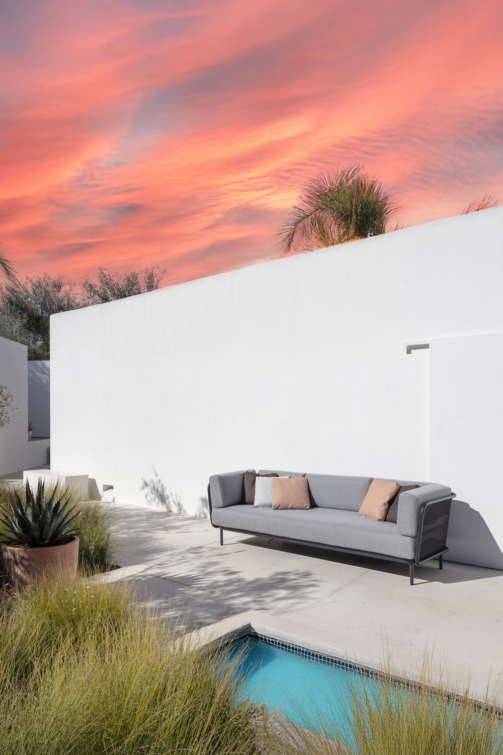 canap&eacute;-confortable-au-design-minimaliste-avec-coussins-de-dossier-ronds-sur-une-terrasse-am&eacute;nag&eacute;e-&agrave;-la-m&eacute;diterran&eacute;enne-avec-piscine