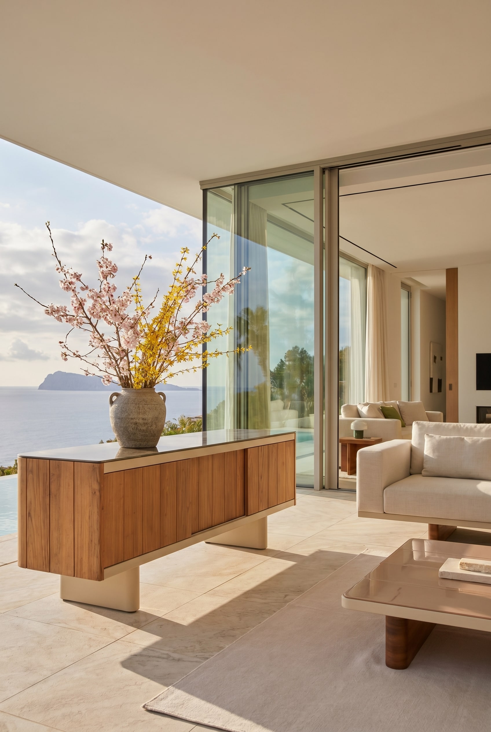 Élégant buffet d'extérieur sur une loggia, décoré d'un grand vase en grès et de branches de printemps Élégant buffet d'extérieur sur une loggia, décoré d'un grand vase en grès et de branches de printemps