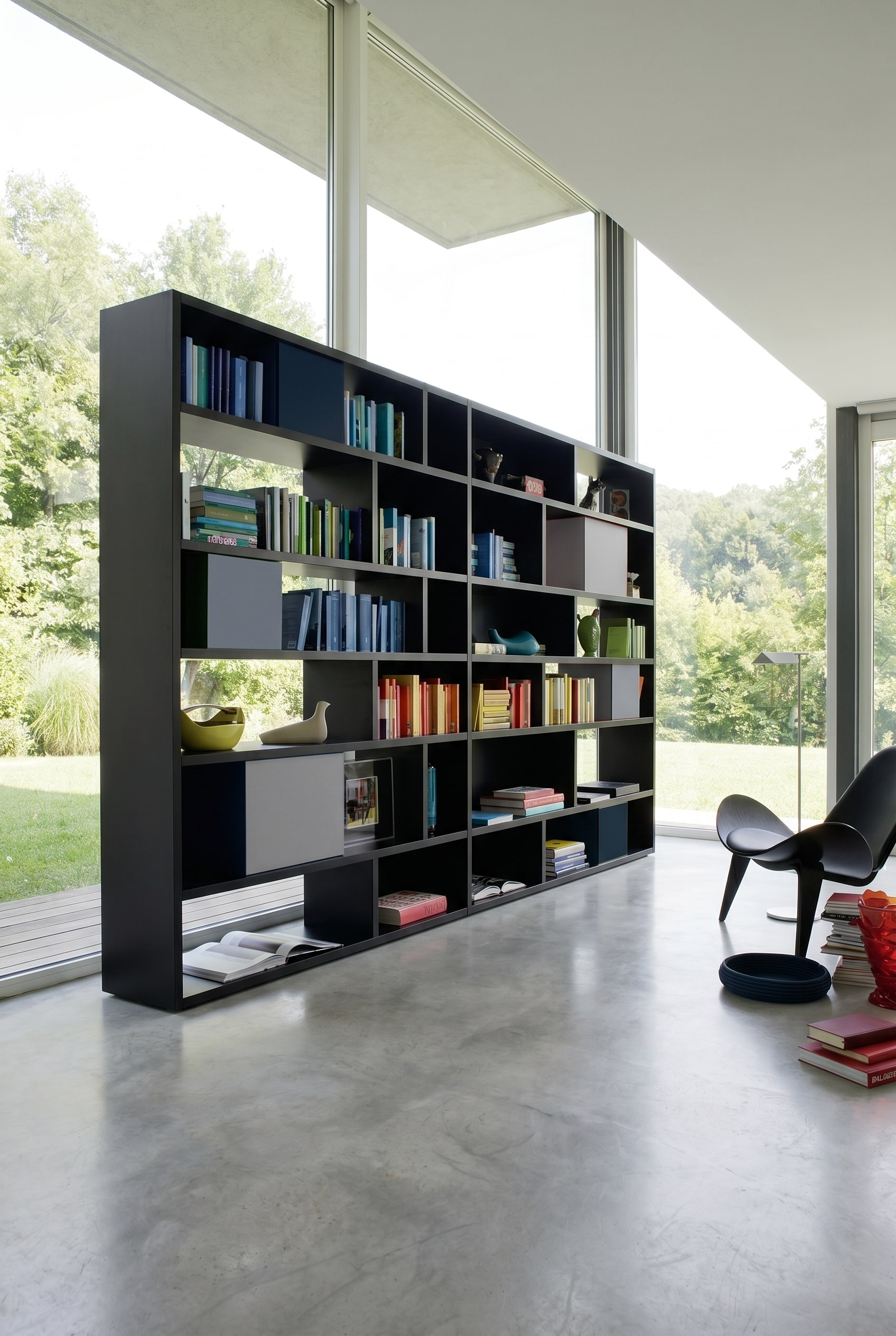 Étagère design asymétrique noir mat avec boîtes de rangement grises et bleues intégrées devant des murs blancs