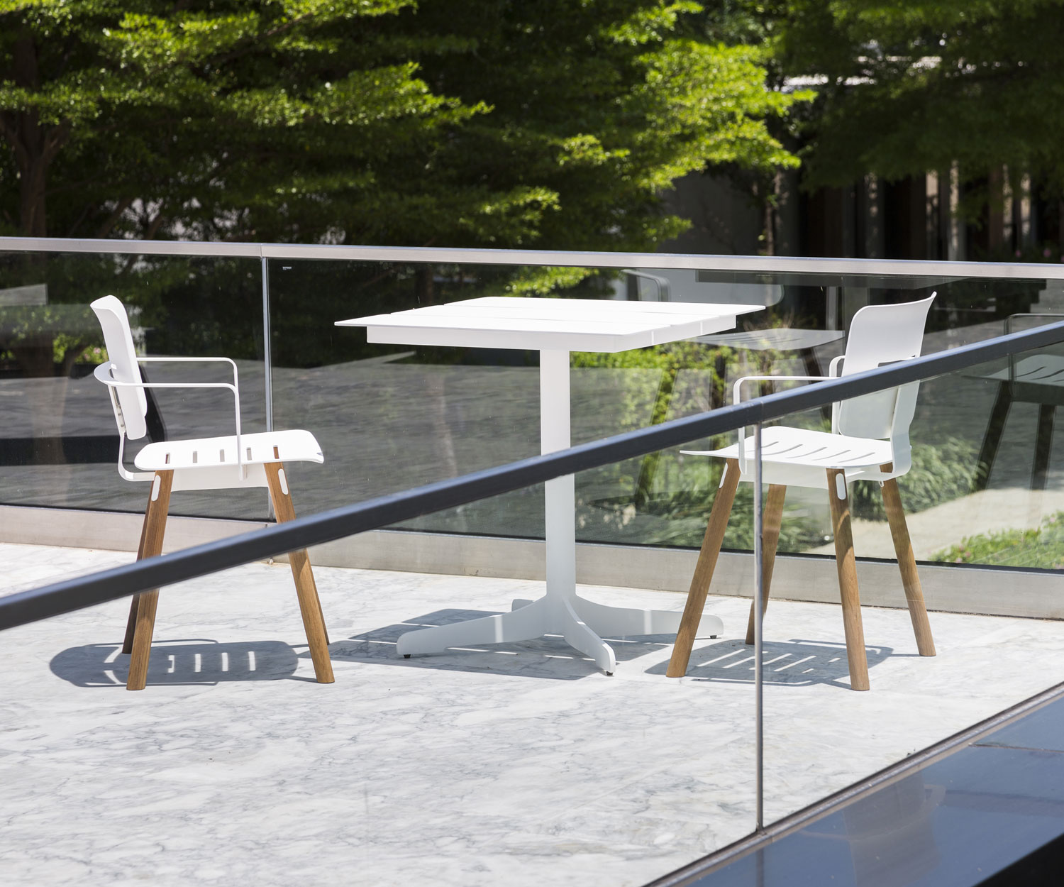 Table de jardin blanche Oasiq Ceru Design avec deux chaises de jardin sur terrasse Table de jardin blanche Oasiq Ceru Design avec deux chaises de jardin sur terrasse