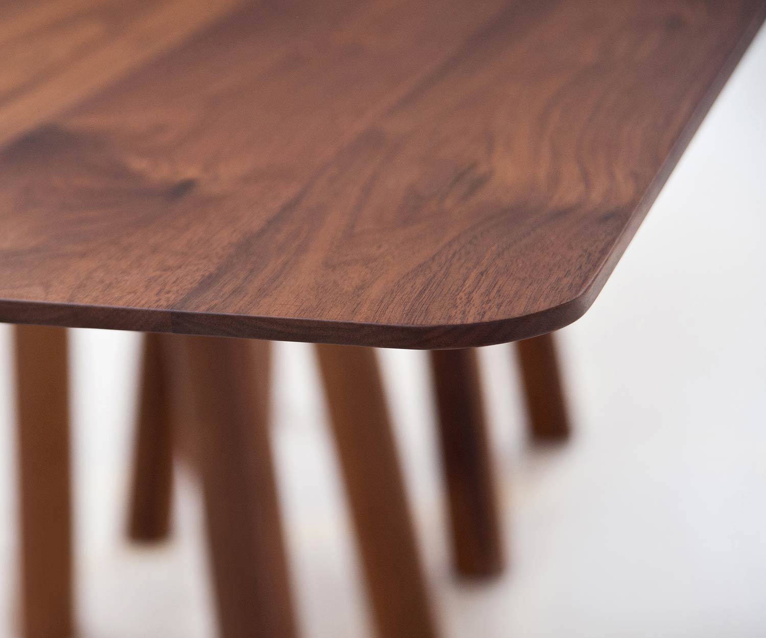 Design eettafel detail concaaf afgeronde hoeken walnoot tafelblad massief hout Design eettafel detail concaaf afgeronde hoeken walnoot tafelblad massief hout
