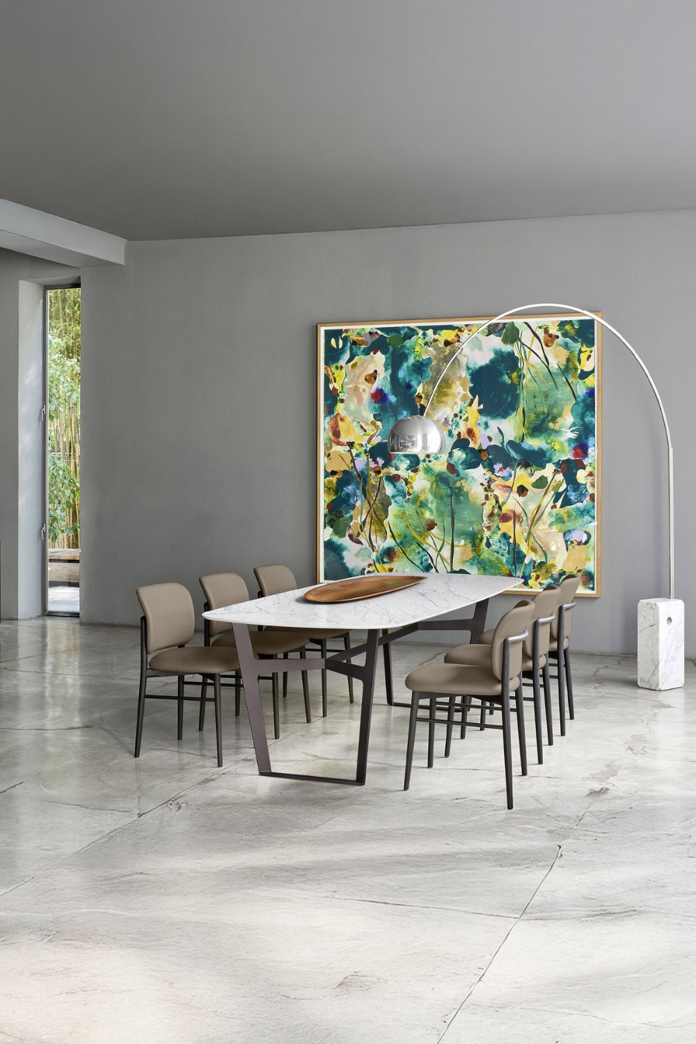 grote-betegelde-eetkamer-met-een-minimalistisch-ontworpen-eethoek-en-booglamp-voor-een-kleurrijk-abstract-muurschildering