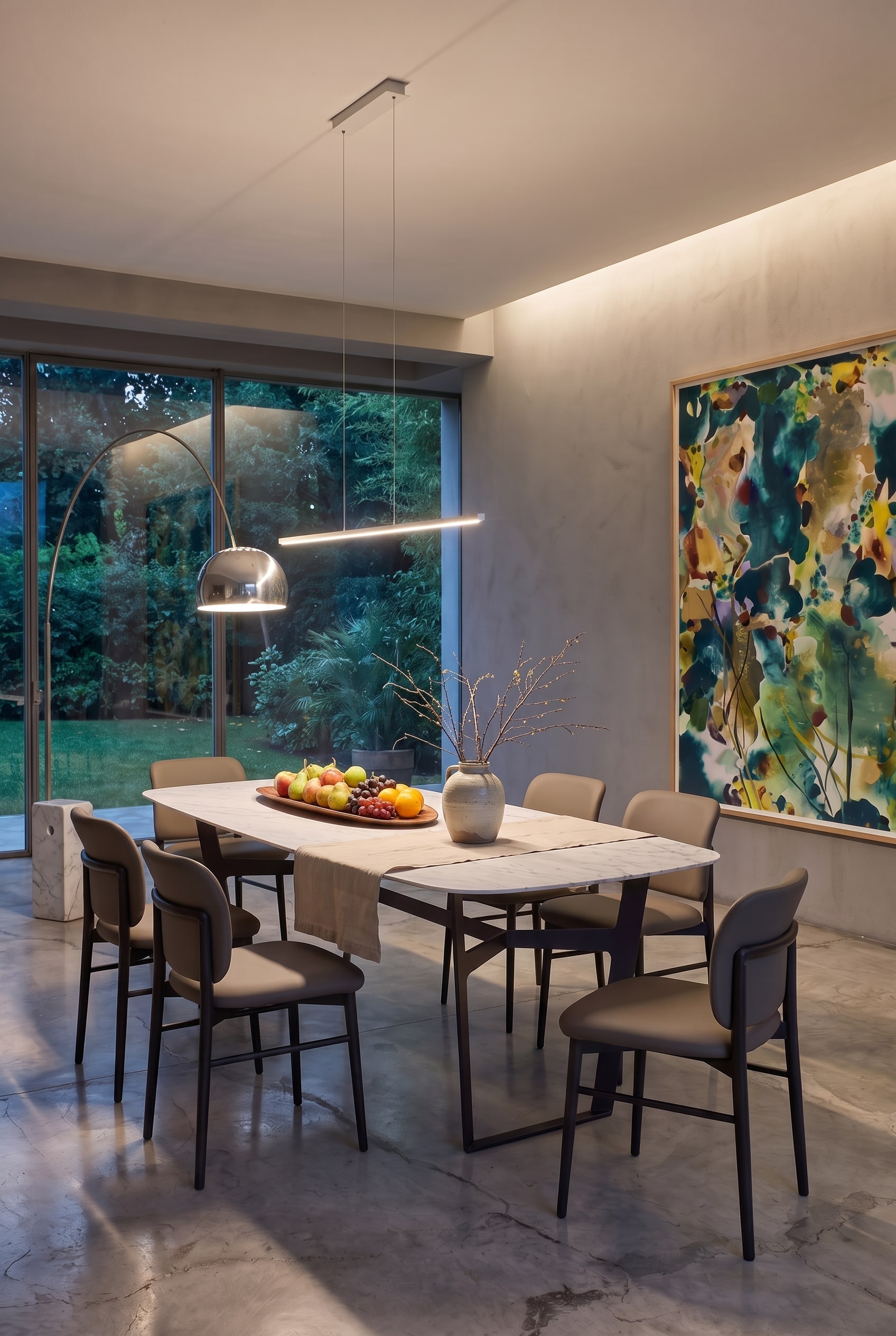 Table &agrave; manger moderne Livitalia Obi dans une salle &agrave; manger de luxe au cr&eacute;puscule avec chemin de table en lin, coupe &agrave; fruits et branches dans un vase en c&eacute;ramique.