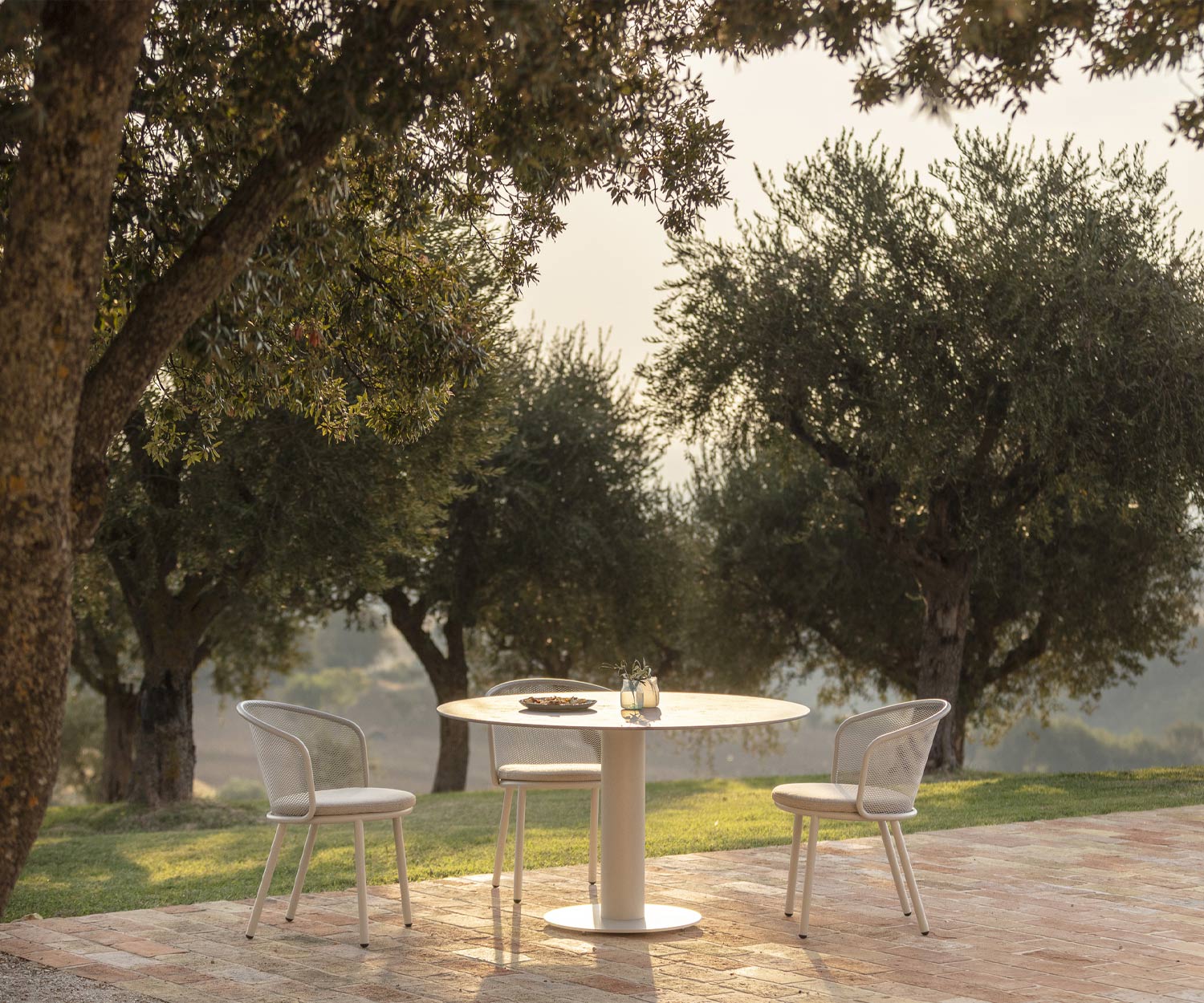Minimalistische Todus Branta tuintafel met ontbijtset onder bomen Minimalistische Todus Branta tuintafel met ontbijtset onder bomen