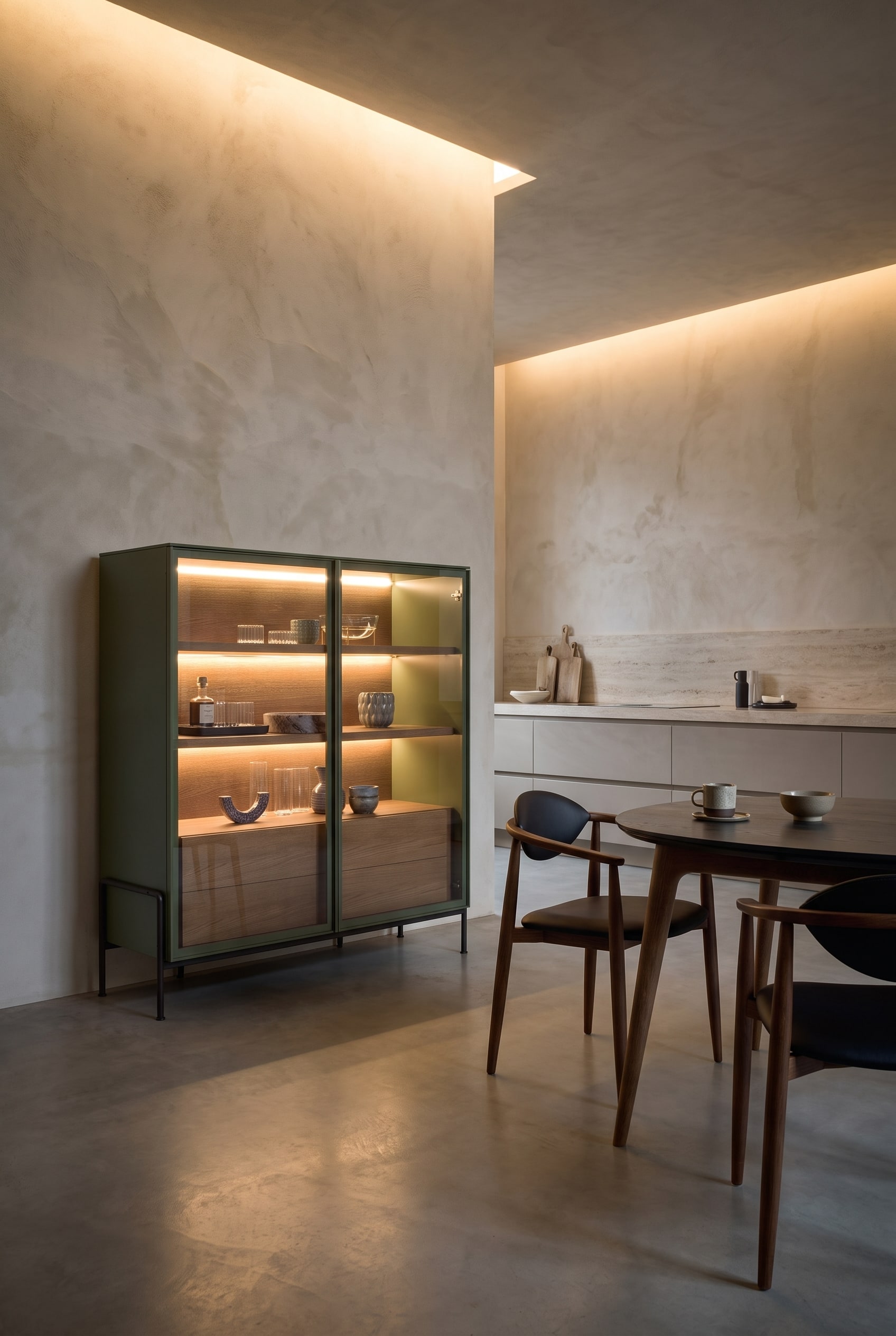 Cuisine ouverte &eacute;l&eacute;gante avec un highboard haut aux bords arrondis, &agrave; c&ocirc;t&eacute; d'une table &agrave; manger minimaliste avec des chaises