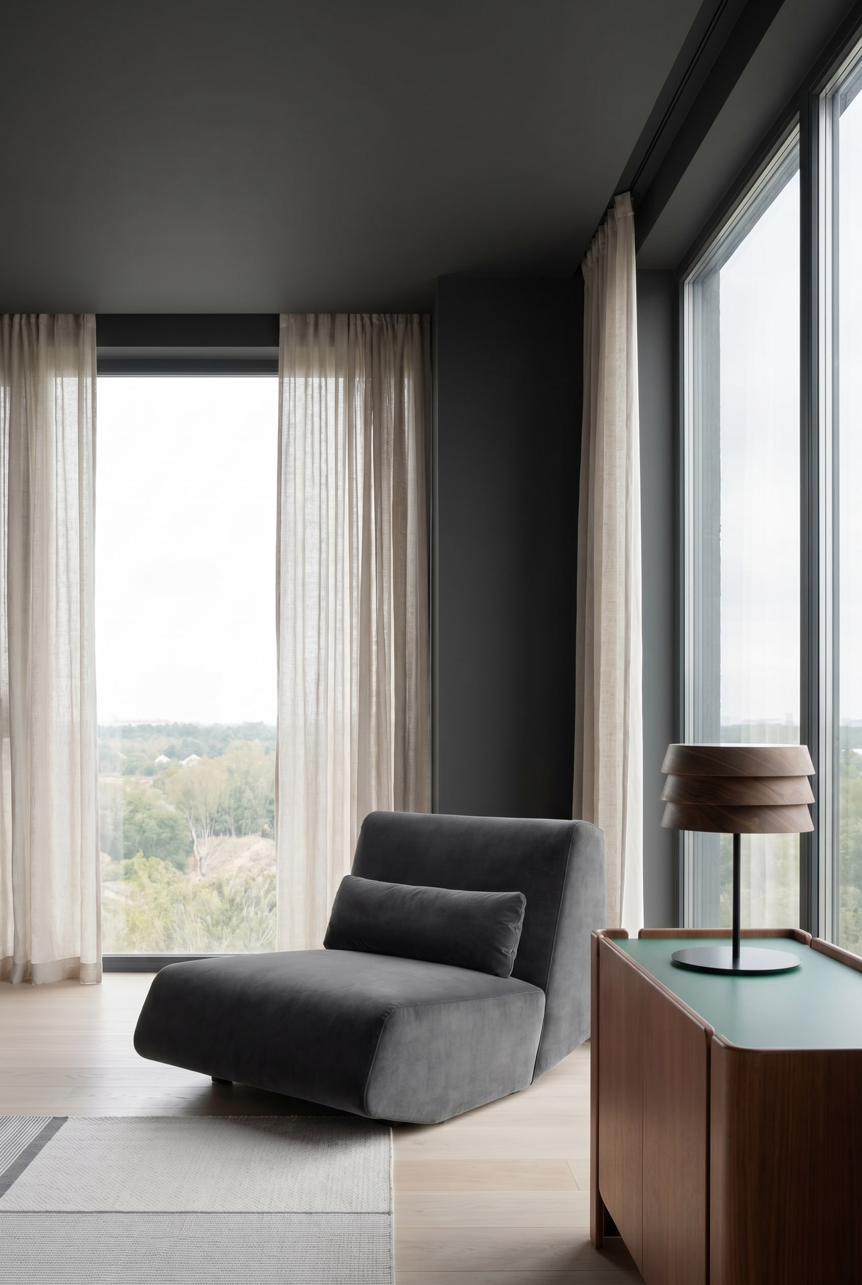 Salon moderne avec fauteuil lounge profond et velout&eacute; en gris fonc&eacute; et murs peints en fonc&eacute; sans raccord