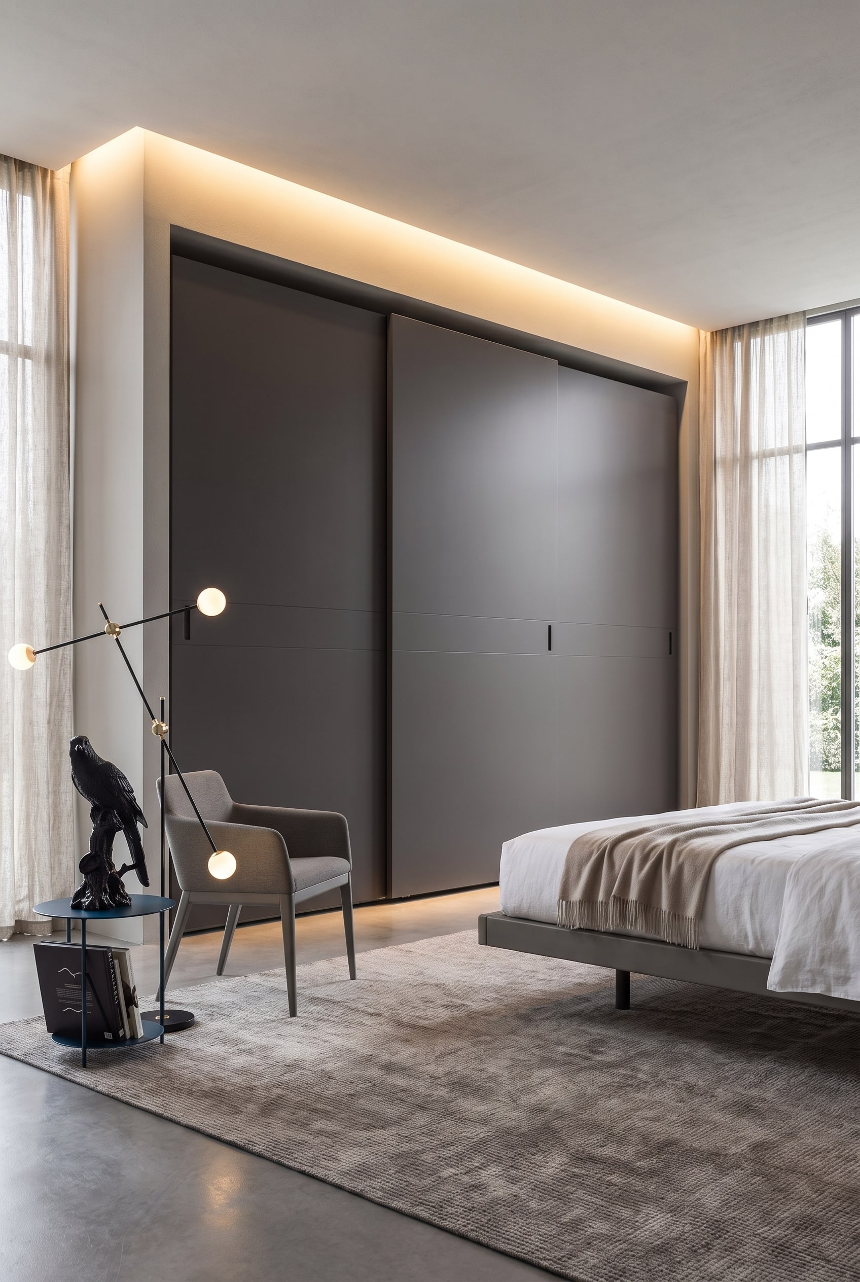 Chambre &agrave; coucher avec une armoire ferm&eacute;e gris clair &agrave; portes coulissantes affleurantes, n&eacute;cessitant tr&egrave;s peu d'espace vers le lit