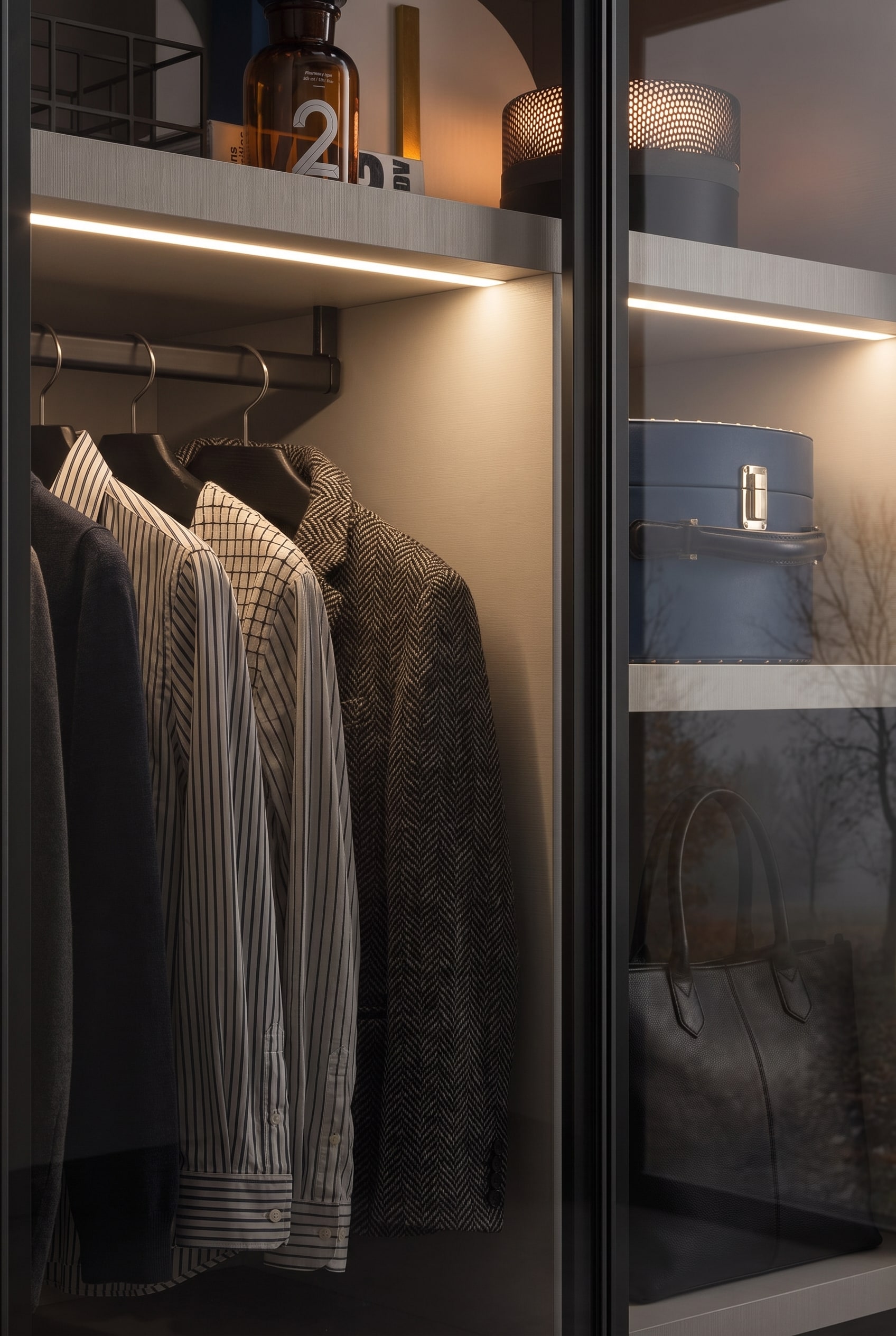 Dressing de haute qualité avec façades en verre fumé, où l'éclairage intérieur indirect et les étagères stables créent une atmosphère de boutique.