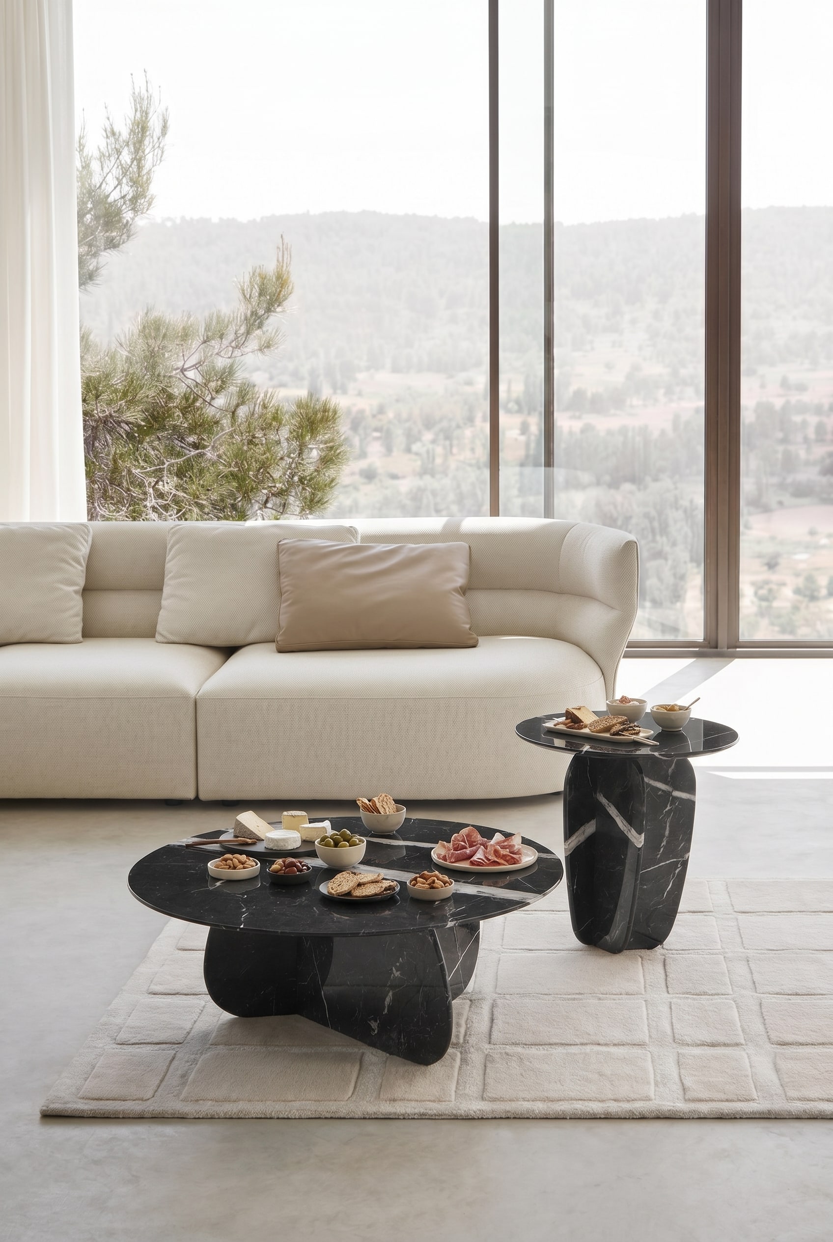 Salon élégant avec deux tables basses rondes en marbre devant un canapé en tissu beige sur un tapis clair