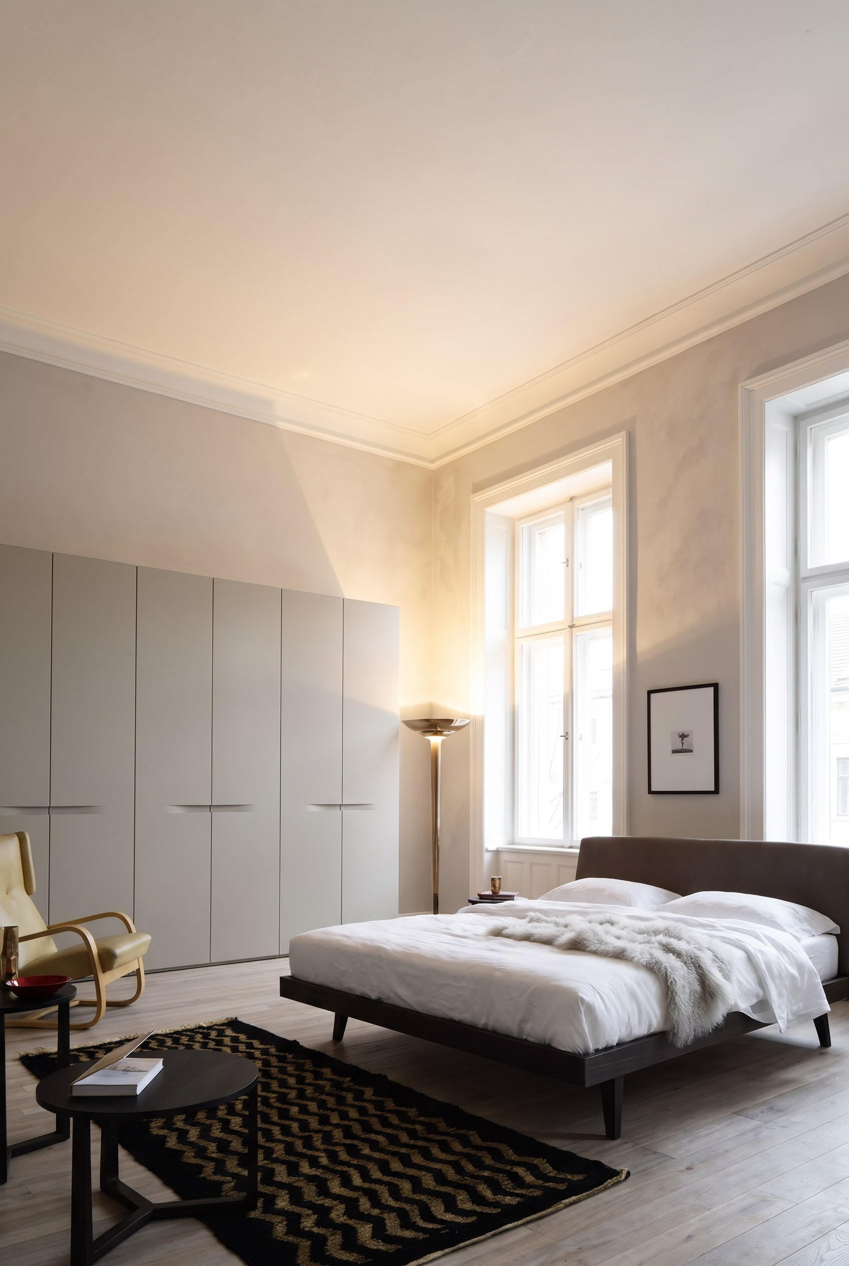 Chambre &eacute;l&eacute;gante de style ancien avec une armoire mate jusqu'au plafond, un lit en bois et des textiles chaleureux