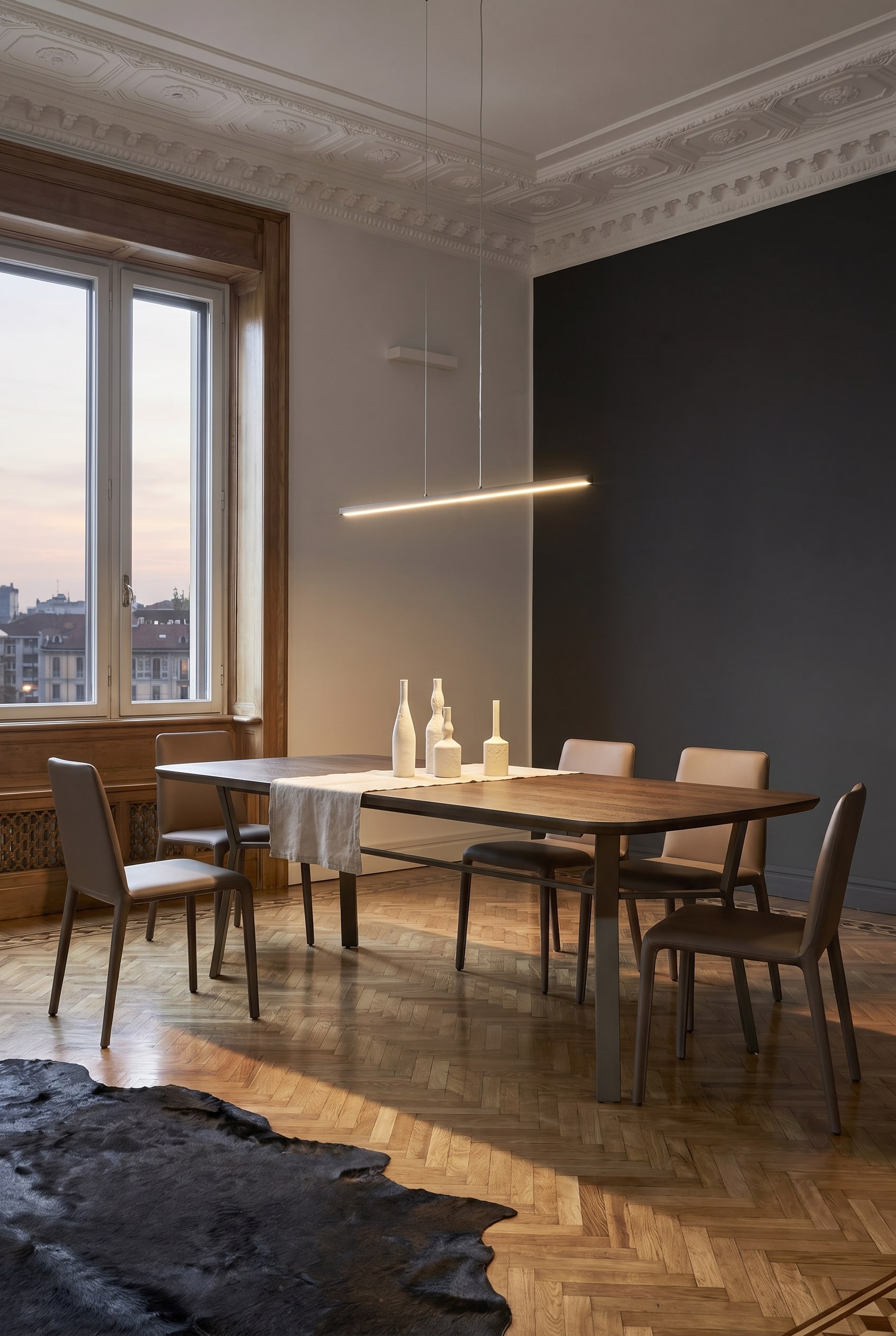 Salle &agrave; manger de style industriel-chic avec une table &agrave; manger lin&eacute;aire, un pi&egrave;tement m&eacute;tallique fonc&eacute; distinctif et des chaises minimalistes