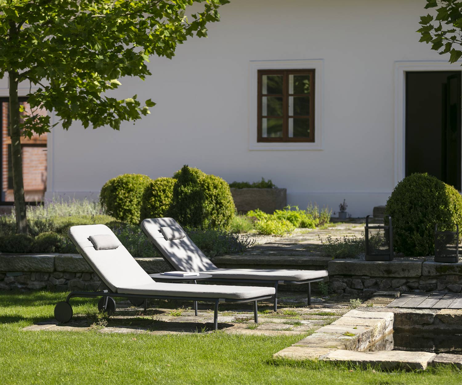 Twee Todus Starling design ligstoelen met optioneel hoofdkussen in de tuin