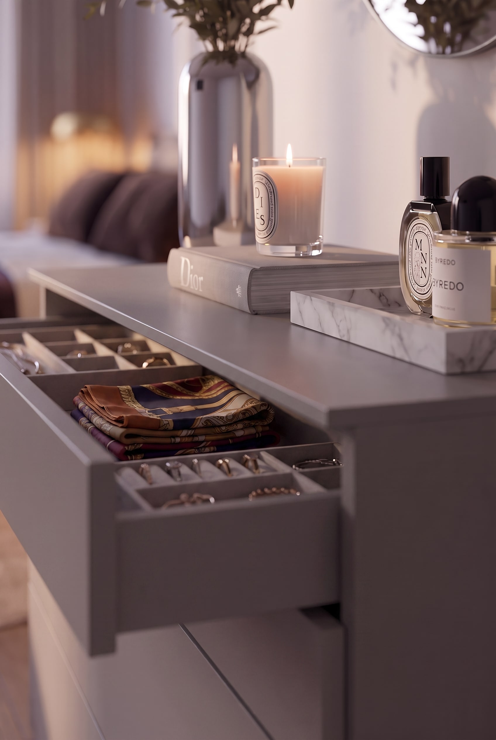 Tiroir de commode ouvert avec organisateur de bijoux sur mesure et foulards en soie pliés.