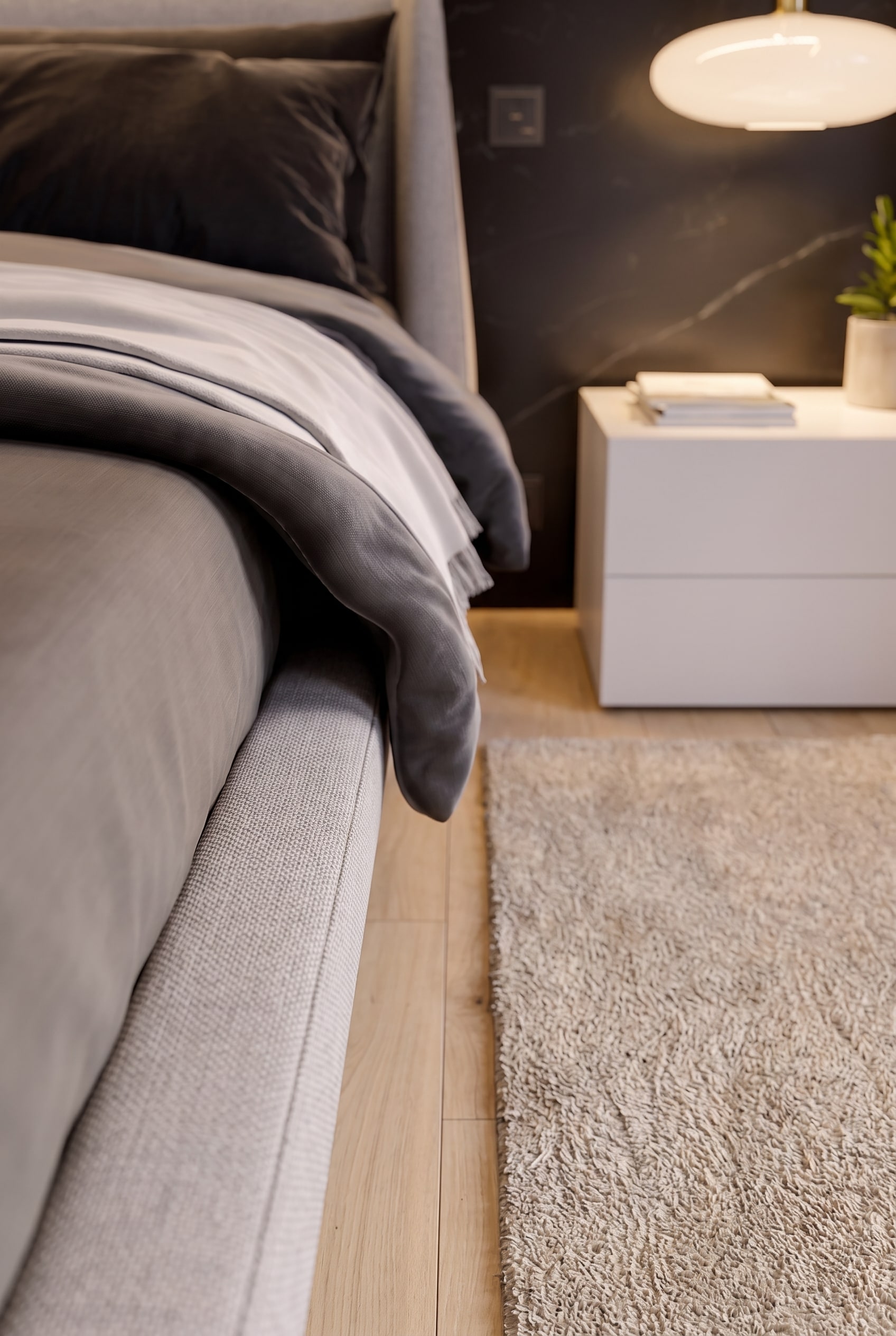 D&eacute;tail d'un joint creux de cinq centim&egrave;tres de large en ch&ecirc;ne clair entre un &eacute;l&eacute;gant lit rembourr&eacute; et un tapis moelleux.