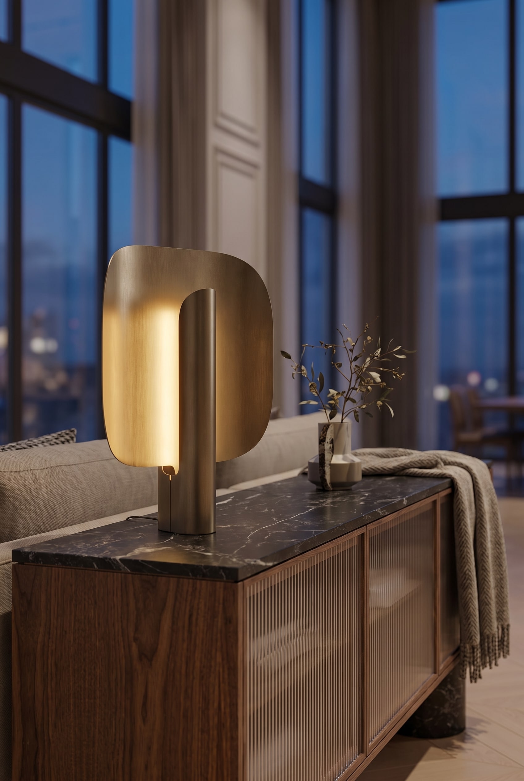 Salon luxueux avec de hauts plafonds, une lampe de table sculpturale sur un élégant buffet en bois et un éclairage d'ambiance indirect