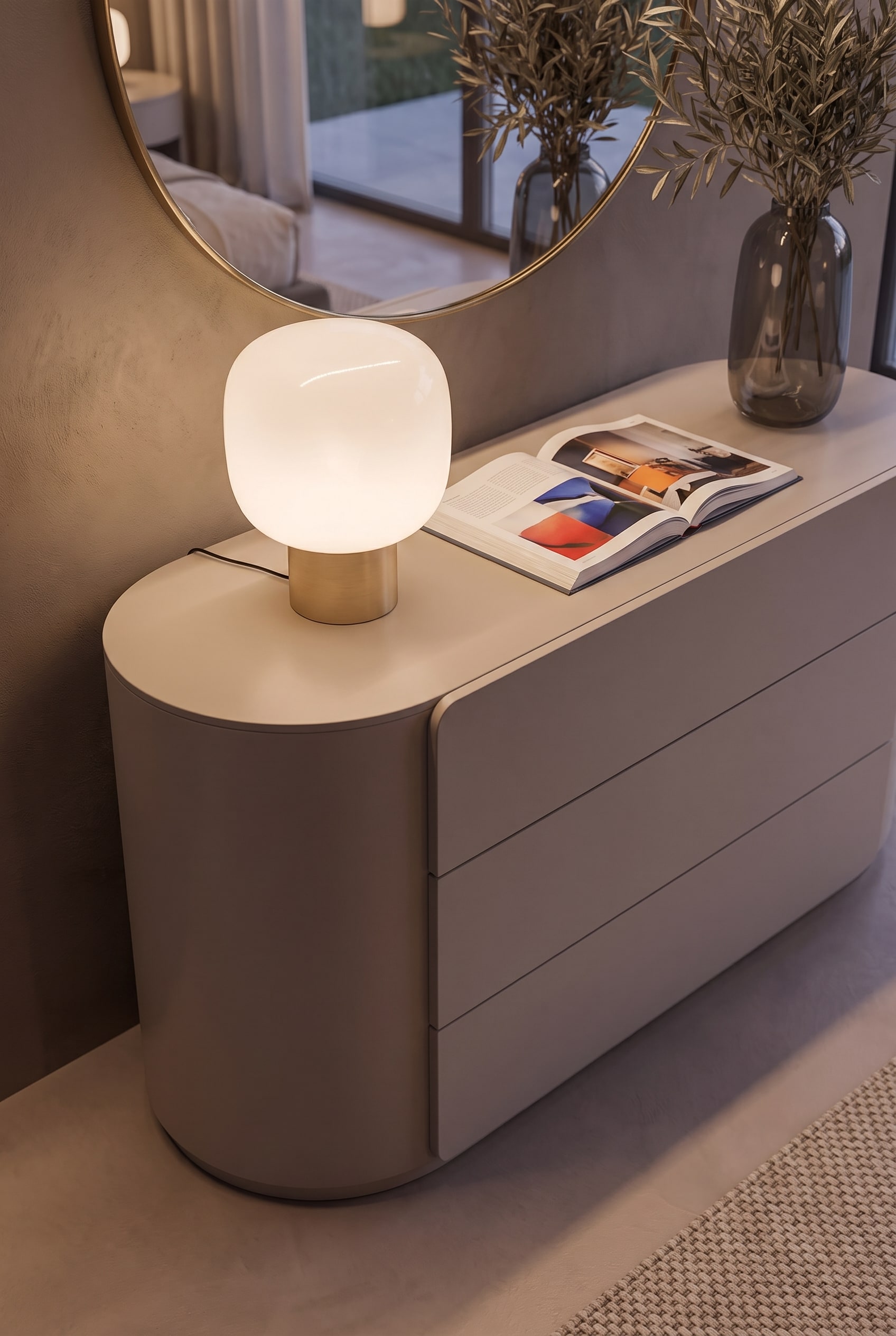 Gros plan du coin arrondi d'une commode mate, montrant le design sans poignée et les jeux de panneaux précis.