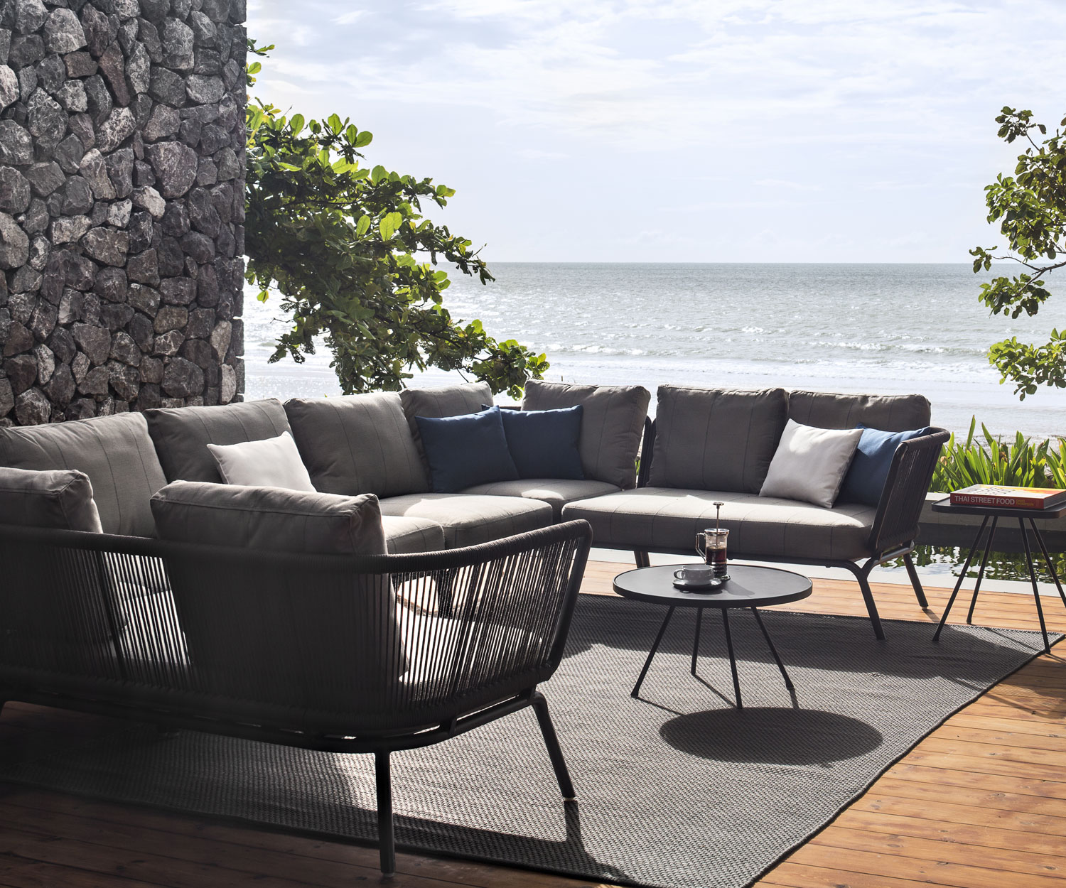 Oasiq Yland Banc d'angle Canapé design avec assise rembourrée en gris sur une terrasse Oasiq Yland Banc d'angle Canapé design avec assise rembourrée en gris sur une terrasse