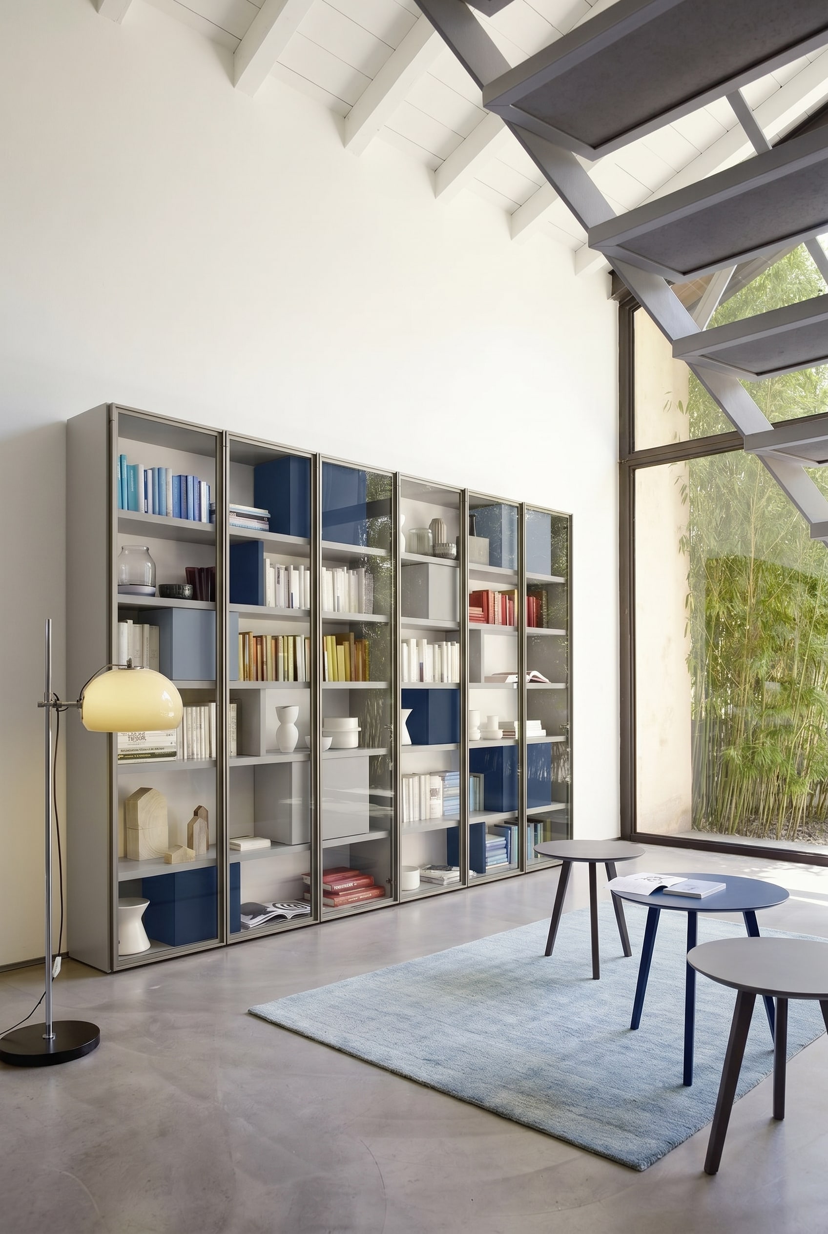 Biblioth&egrave;que gris clair sur mesure avec des espacements minimaux entre les &eacute;tag&egrave;res et des bo&icirc;tes bleues int&eacute;gr&eacute;es