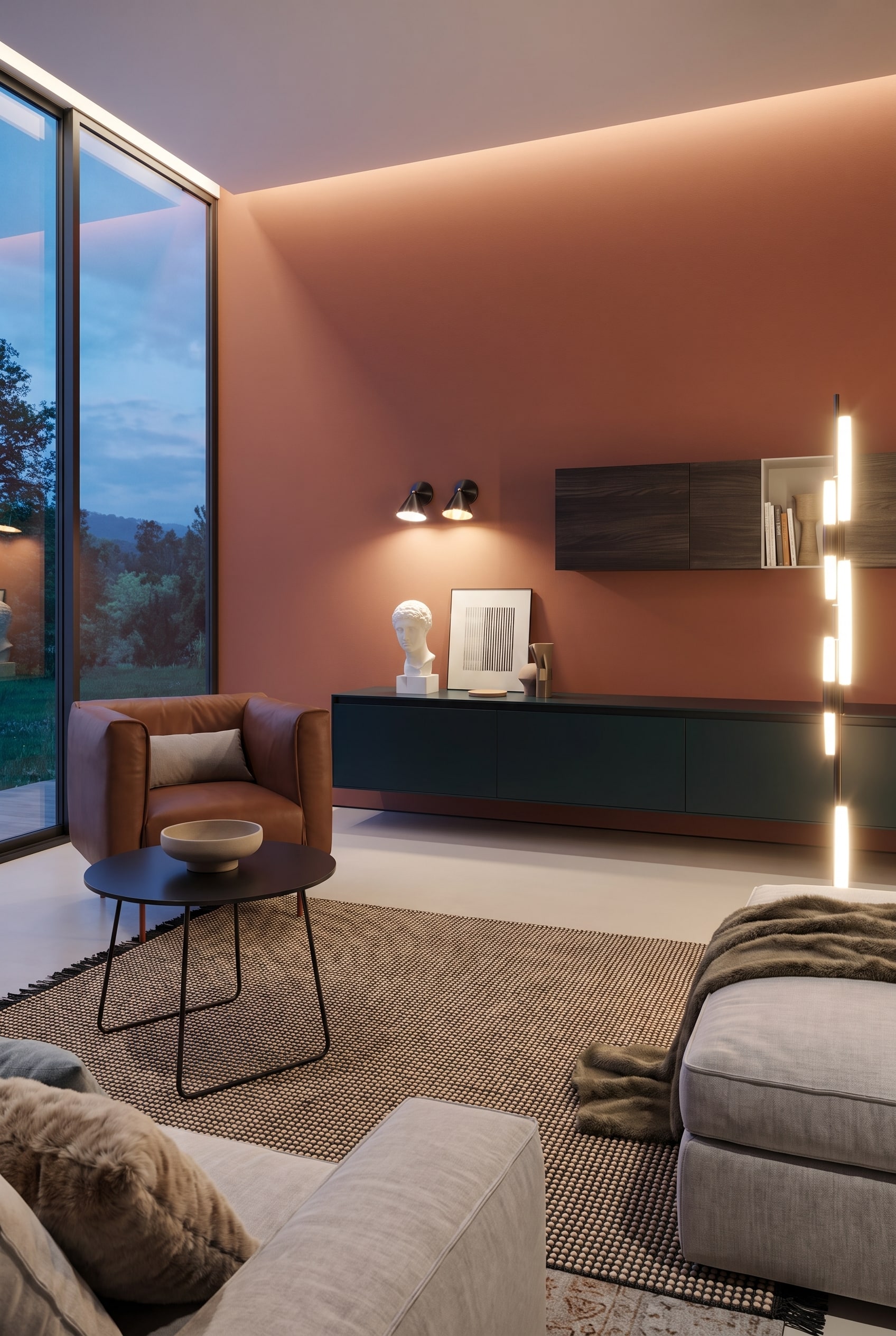 Salon avec mur couleur terre cuite, grandes fen&ecirc;tres et une table basse ronde avec pi&egrave;tement en m&eacute;tal noir