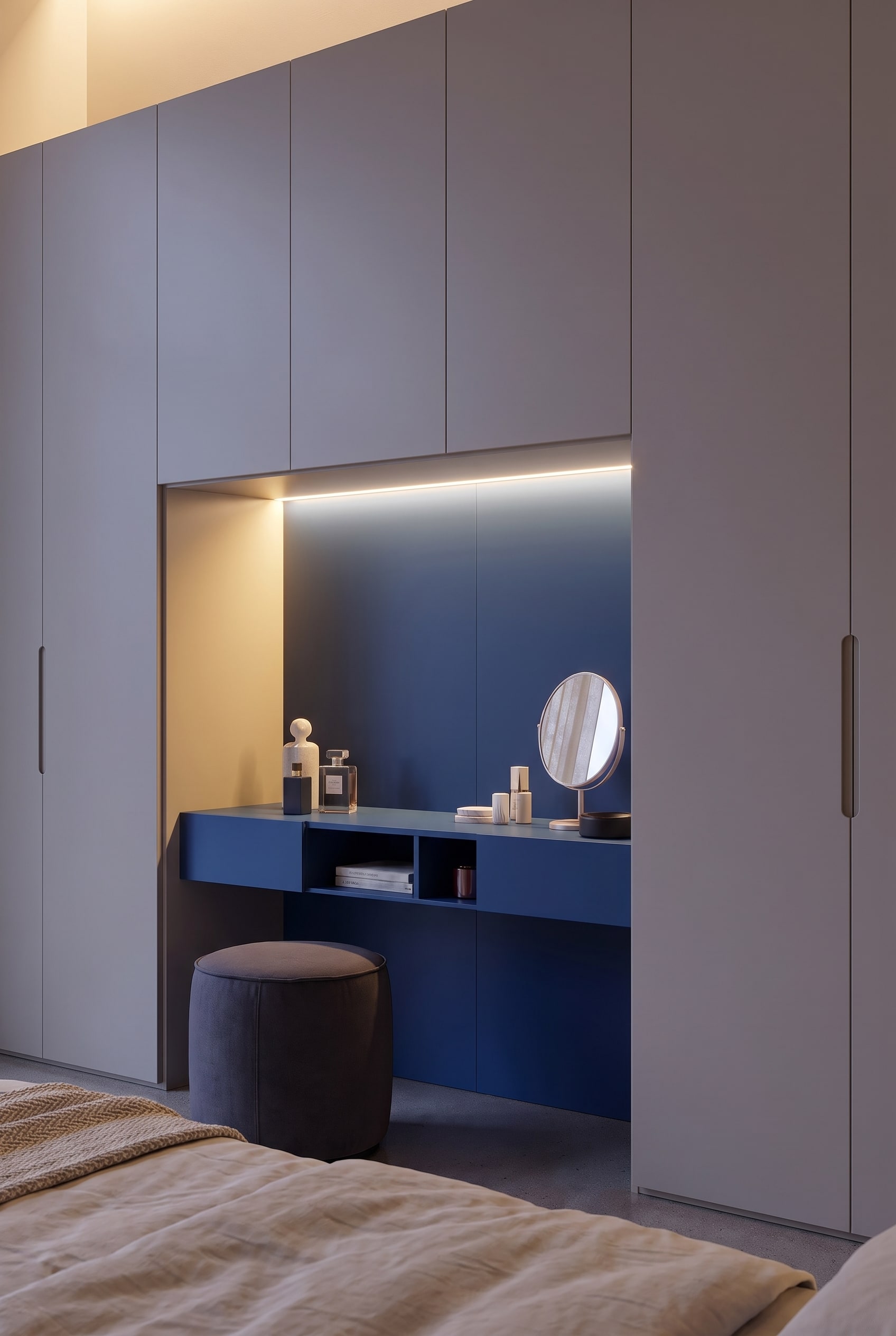Vue détaillée de la niche d'armoire bleue avec coiffeuse éclairée, miroir rond et flacons de parfum.
