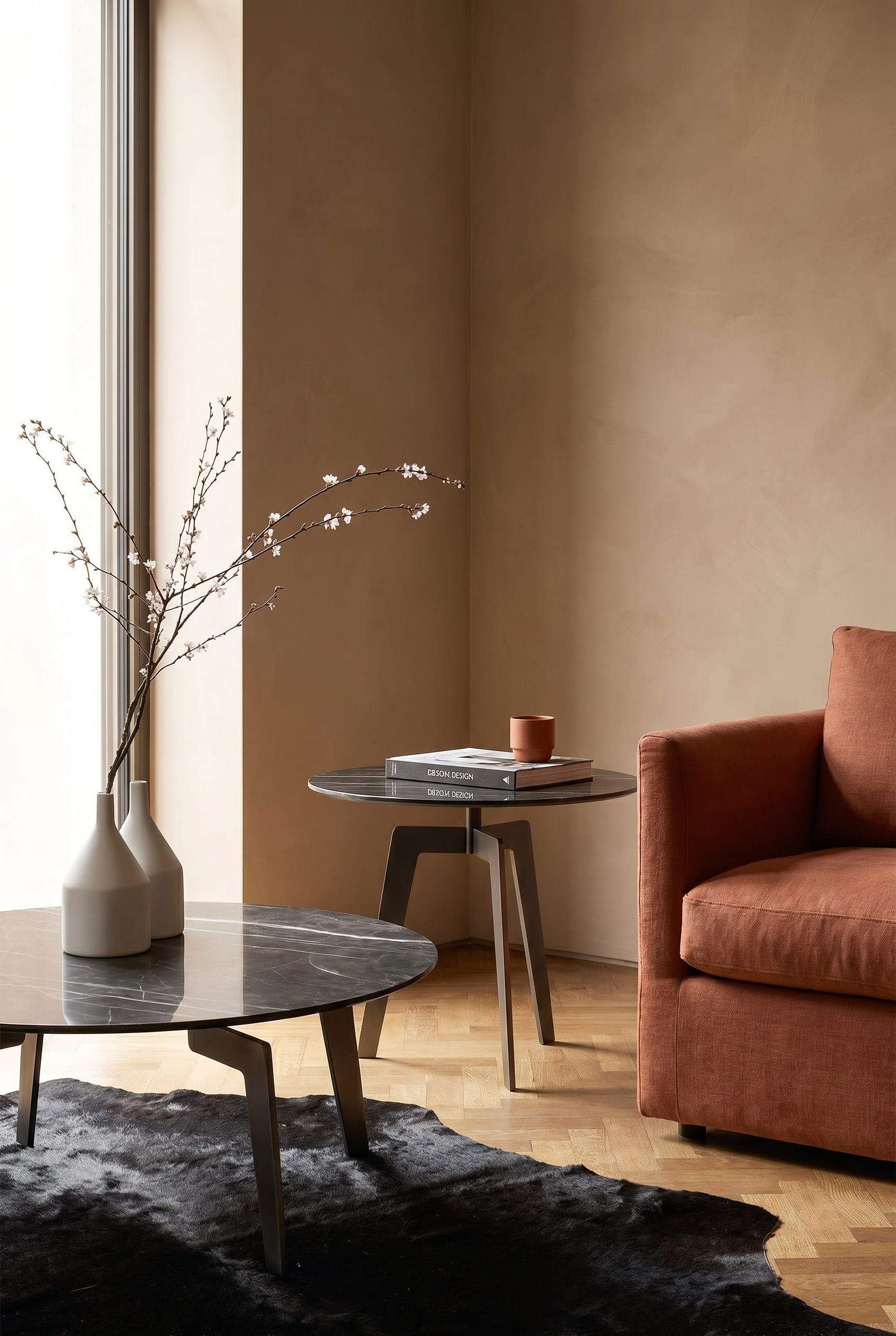 Coin salon avec table d'appoint en marbre foncé à côté d'un fauteuil couleur terre cuite