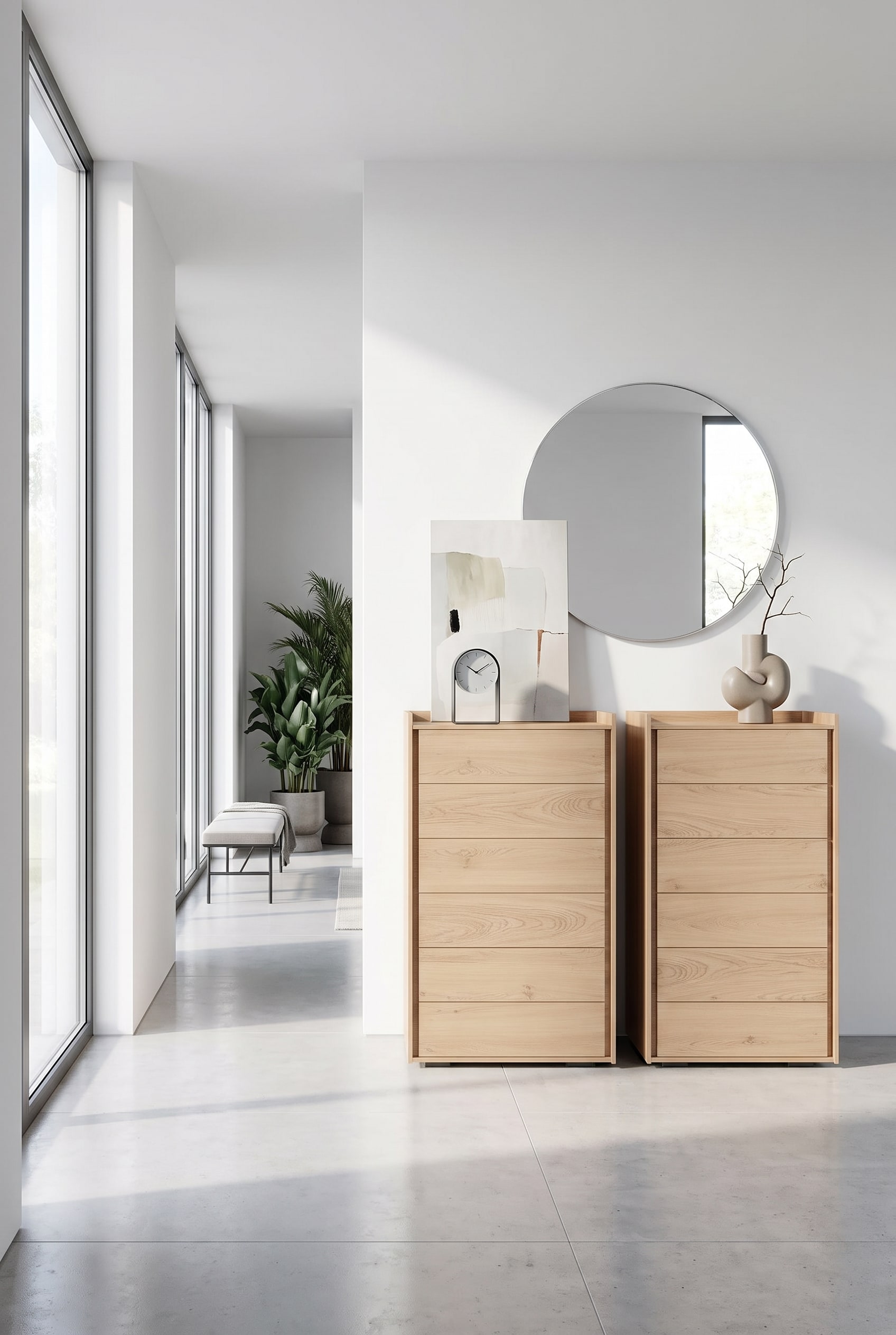 Commode haute étroite en bois clair dans le couloir, sur le plateau une horloge de table élégante et un tableau minimaliste appuyé