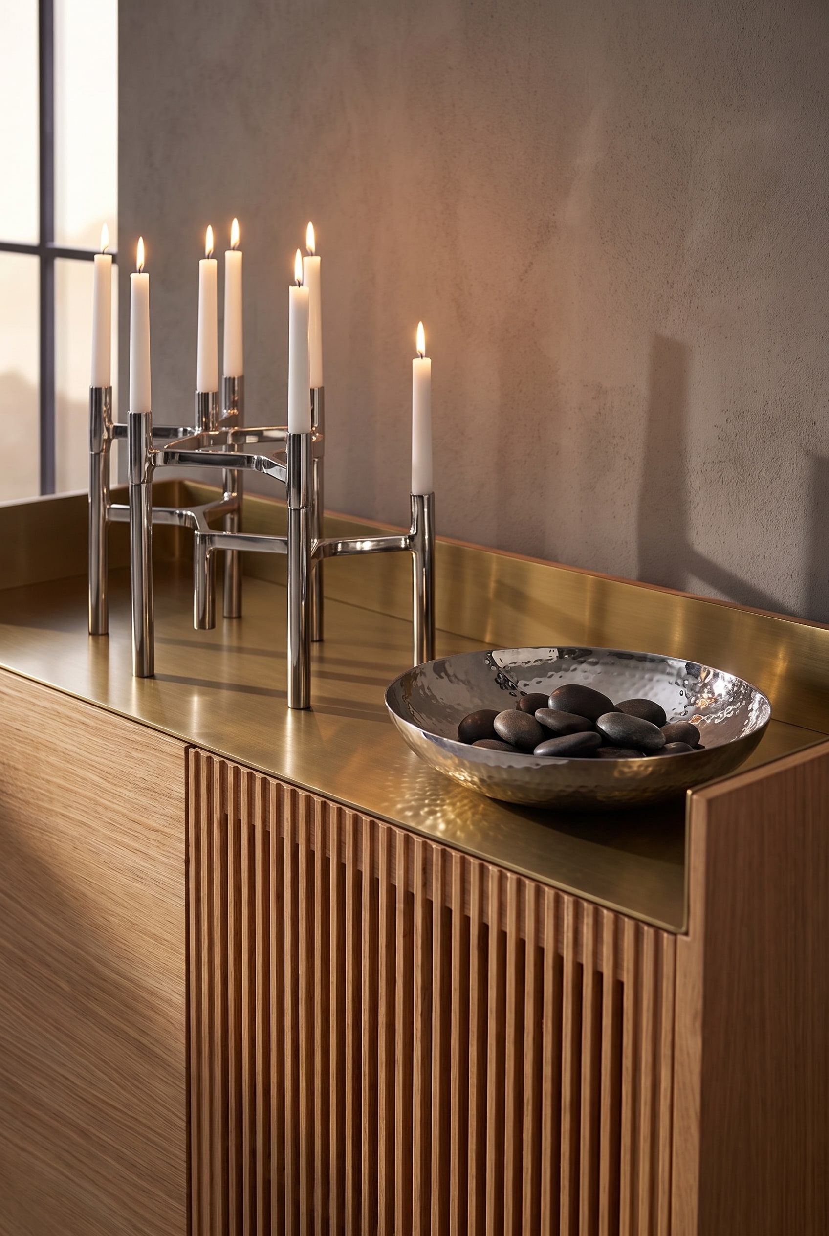 Sideboard en ch&ecirc;ne clair avec fa&ccedil;ade &agrave; lattes et plateau en aluminium, agr&eacute;ment&eacute; de bougeoirs argent&eacute;s froids et d'une coupelle en acier inoxydable