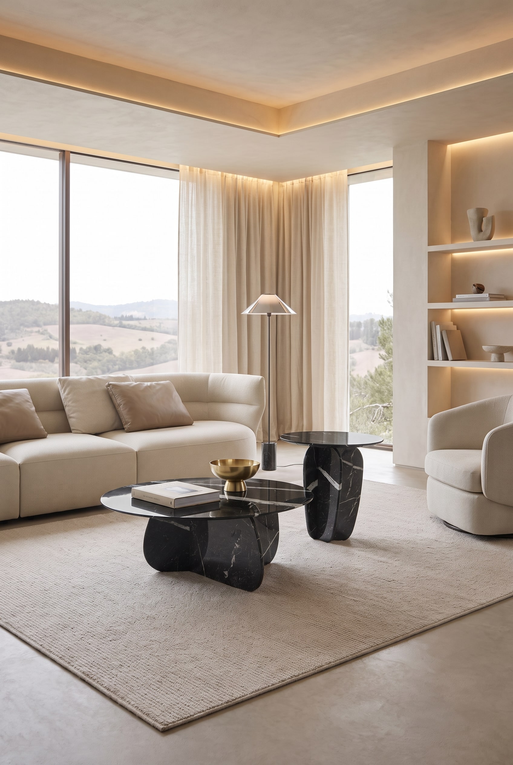 Salon avec deux tables basses de forme organique en marbre fonc&eacute; sur un tapis clair, en arri&egrave;re-plan des fen&ecirc;tres pleine hauteur et un &eacute;clairage indirect