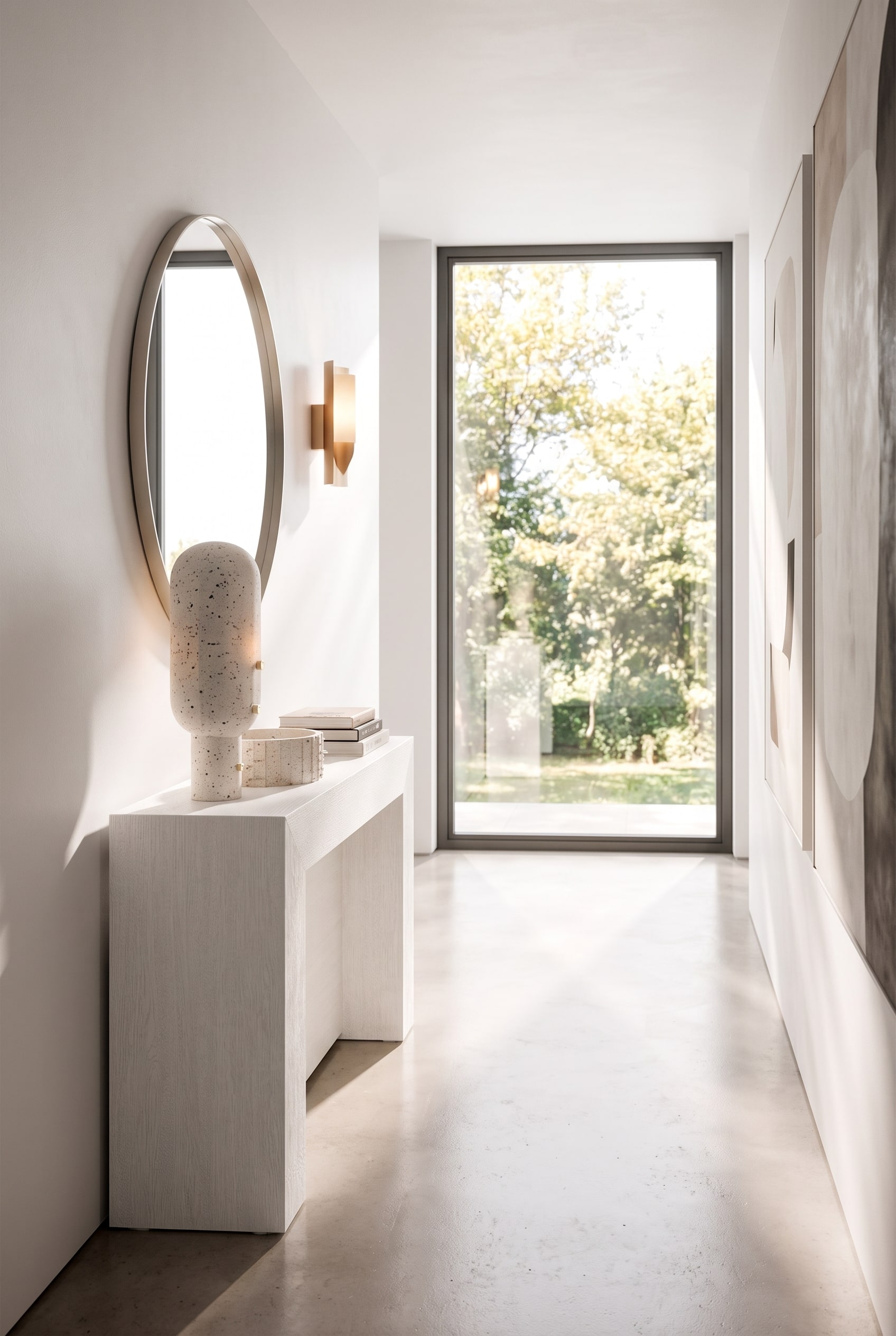 Couloir &eacute;troit avec une console blanche ultra-plate, au-dessus, un miroir mural rond et une applique murale minimaliste