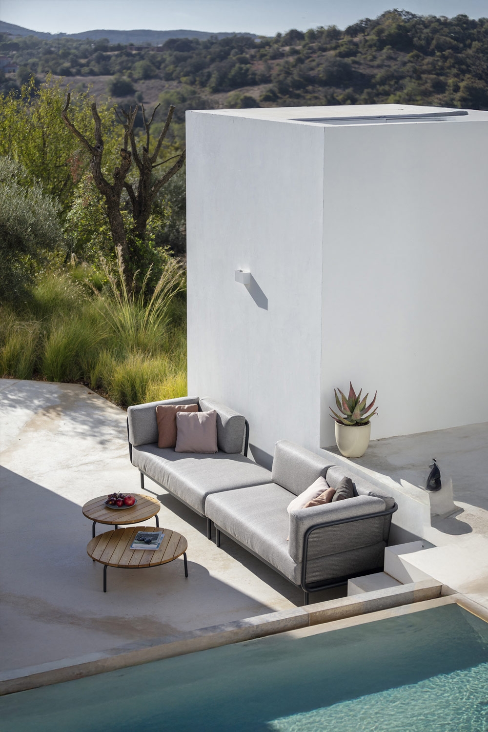 grand-canapé-lounge-avec-beaucoup-de-coussins-décoratifs-et-deux-tables-d'appoint