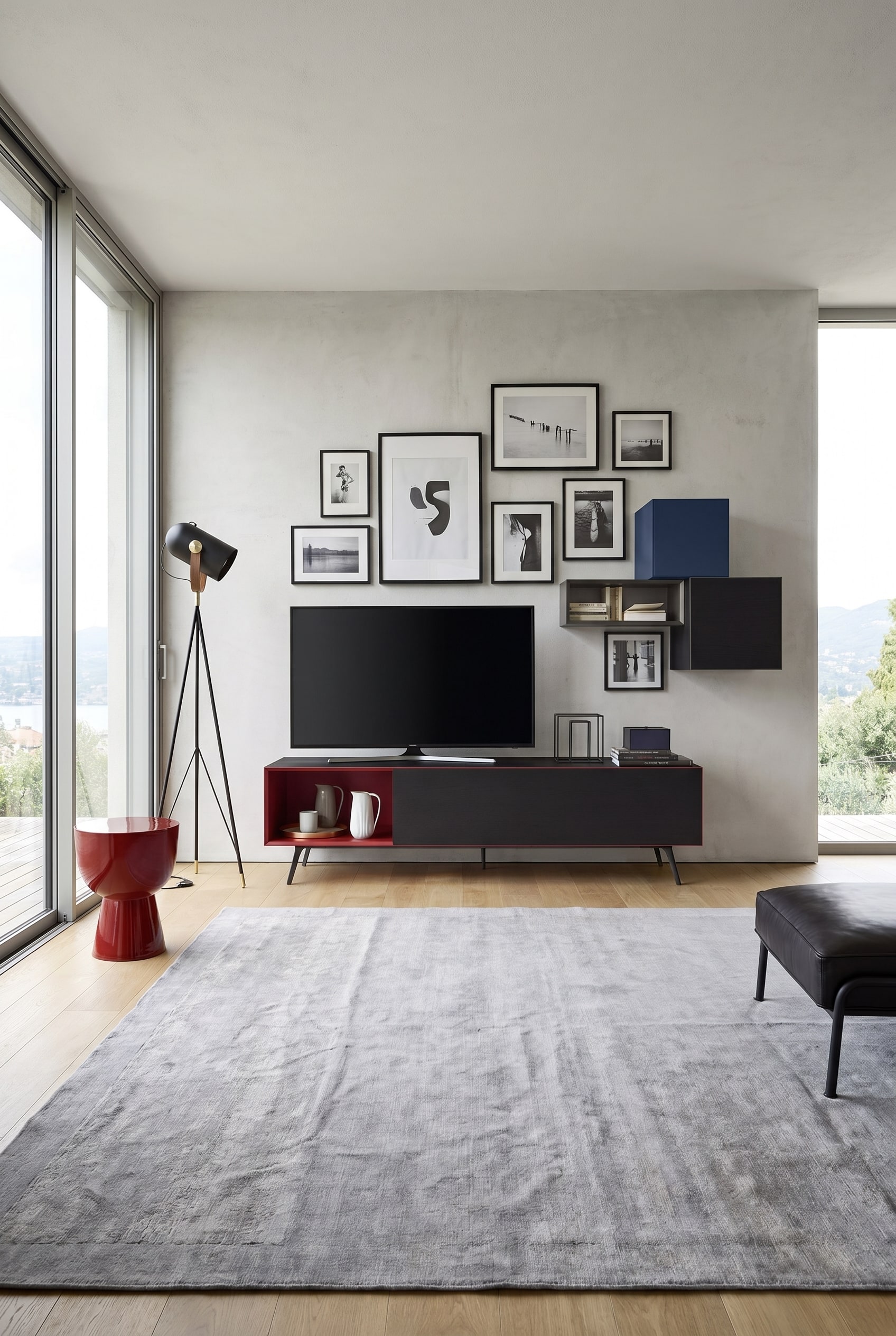 Meuble bas minimaliste avec des compartiments rouges ouverts et des fa&ccedil;ades noires sous un mur de galerie de salon
