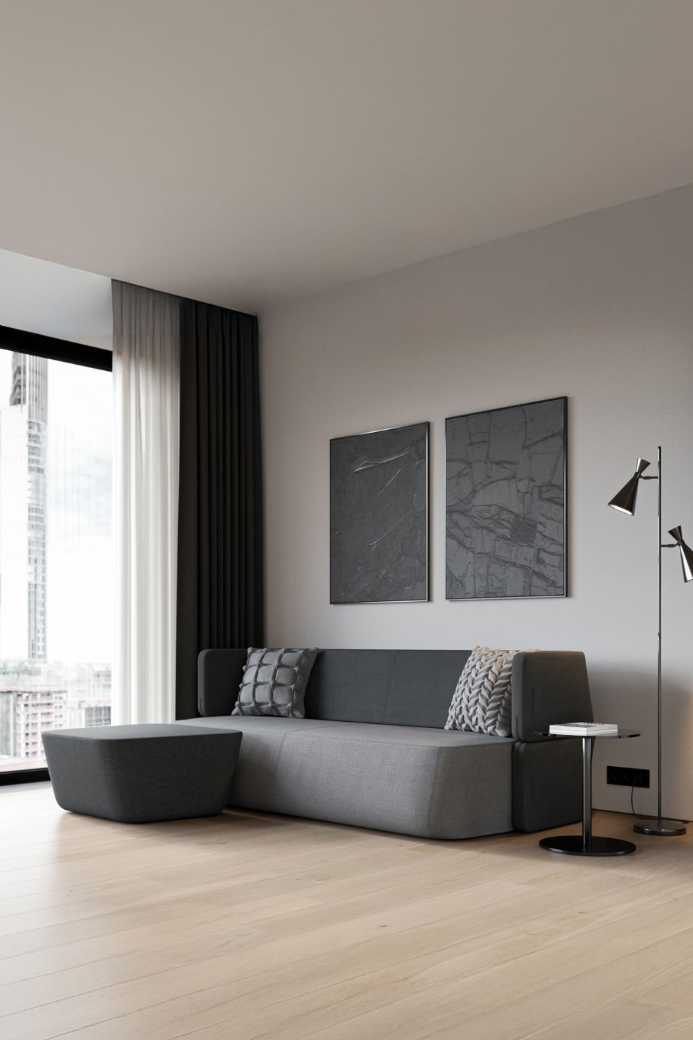 canap&eacute;-lit gris aux bords arrondis compl&eacute;t&eacute; par un pouf assorti et une table d'appoint ronde