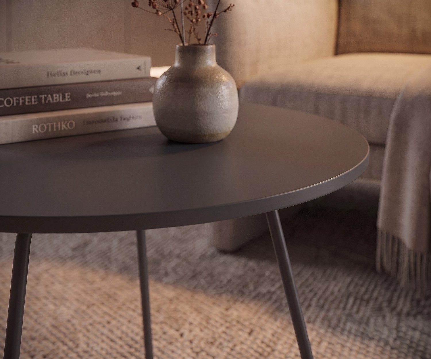 Table d'appoint Orbis de Novamobili dans le salon. Table basse ronde grise près d'un fauteuil avec livres et vase.