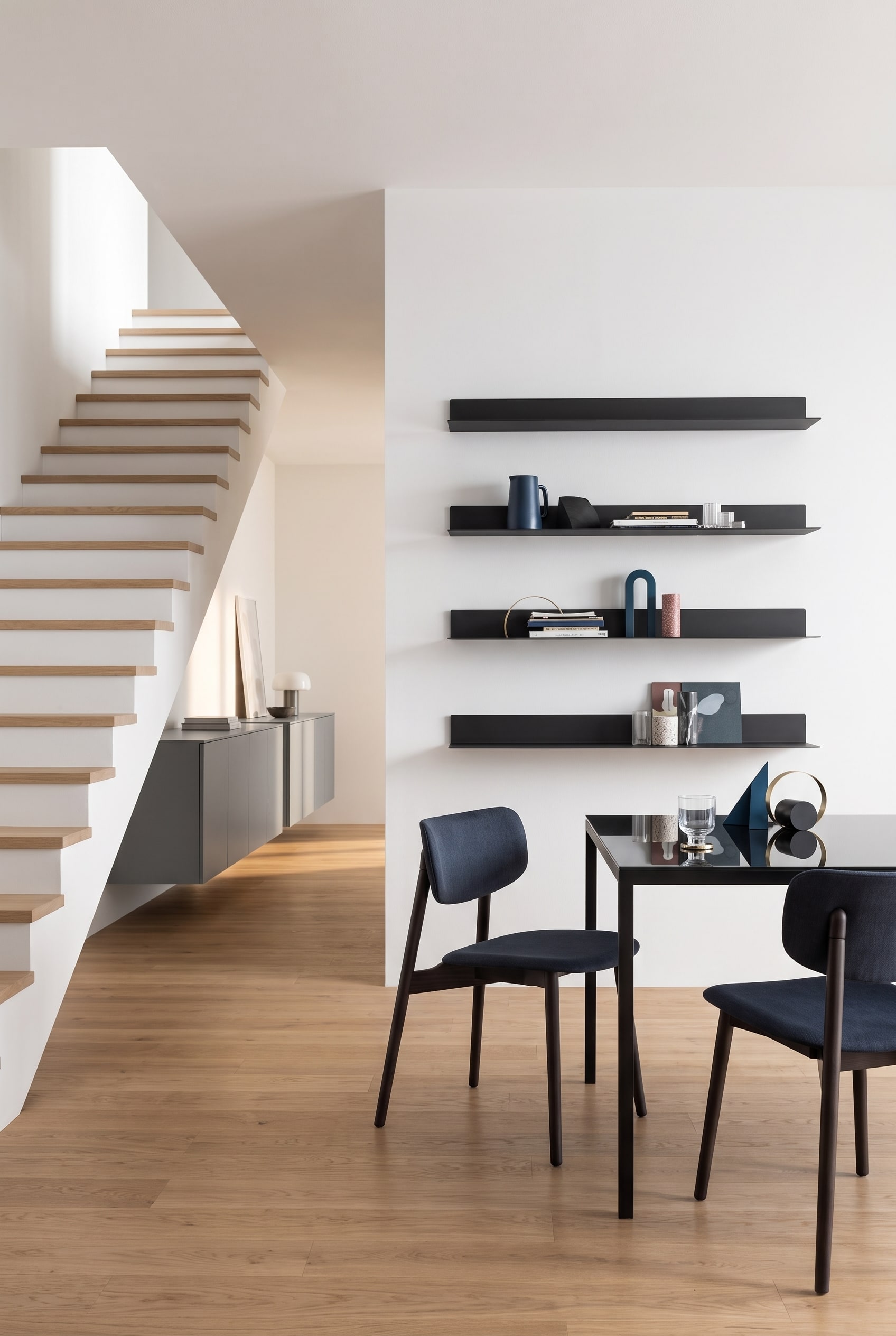 Un élégant buffet Punt Rio avec façades fermées dans le couloir à côté d'un escalier en bois moderne.