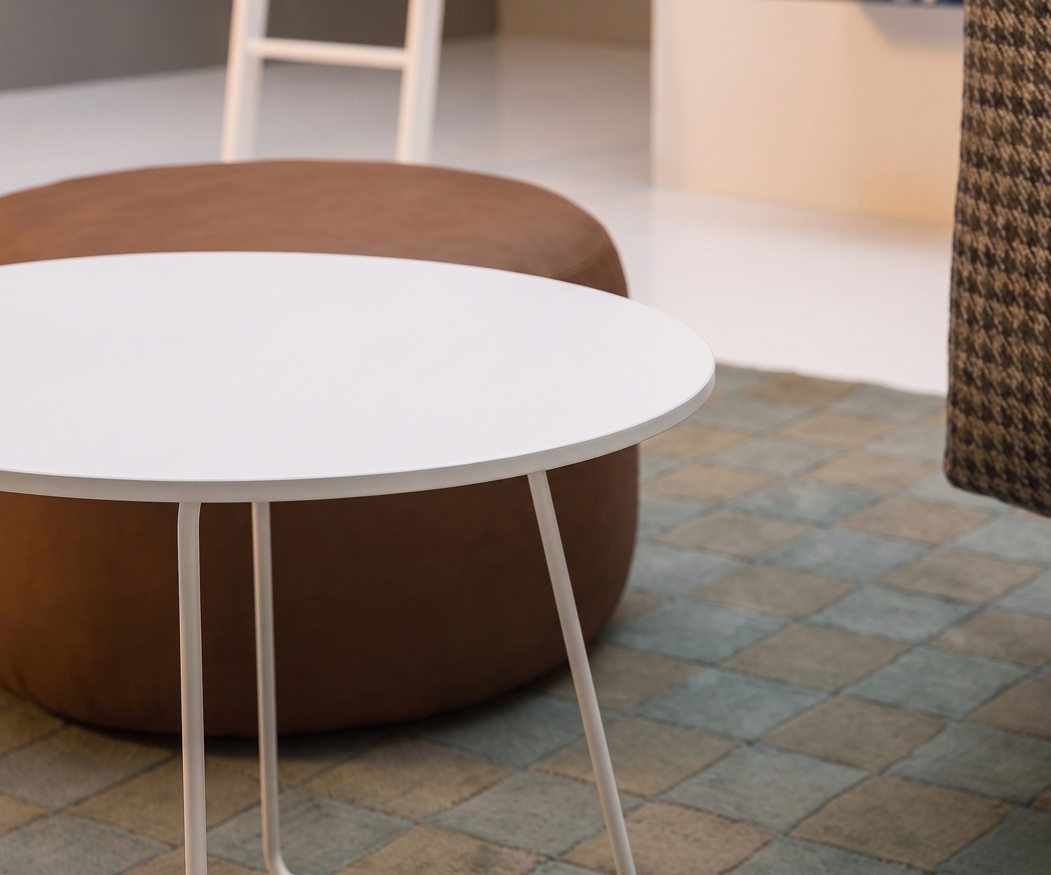 Table d'appoint Novamobili Orbis dans un salon près d'un pouf marron, table basse ronde blanche design.