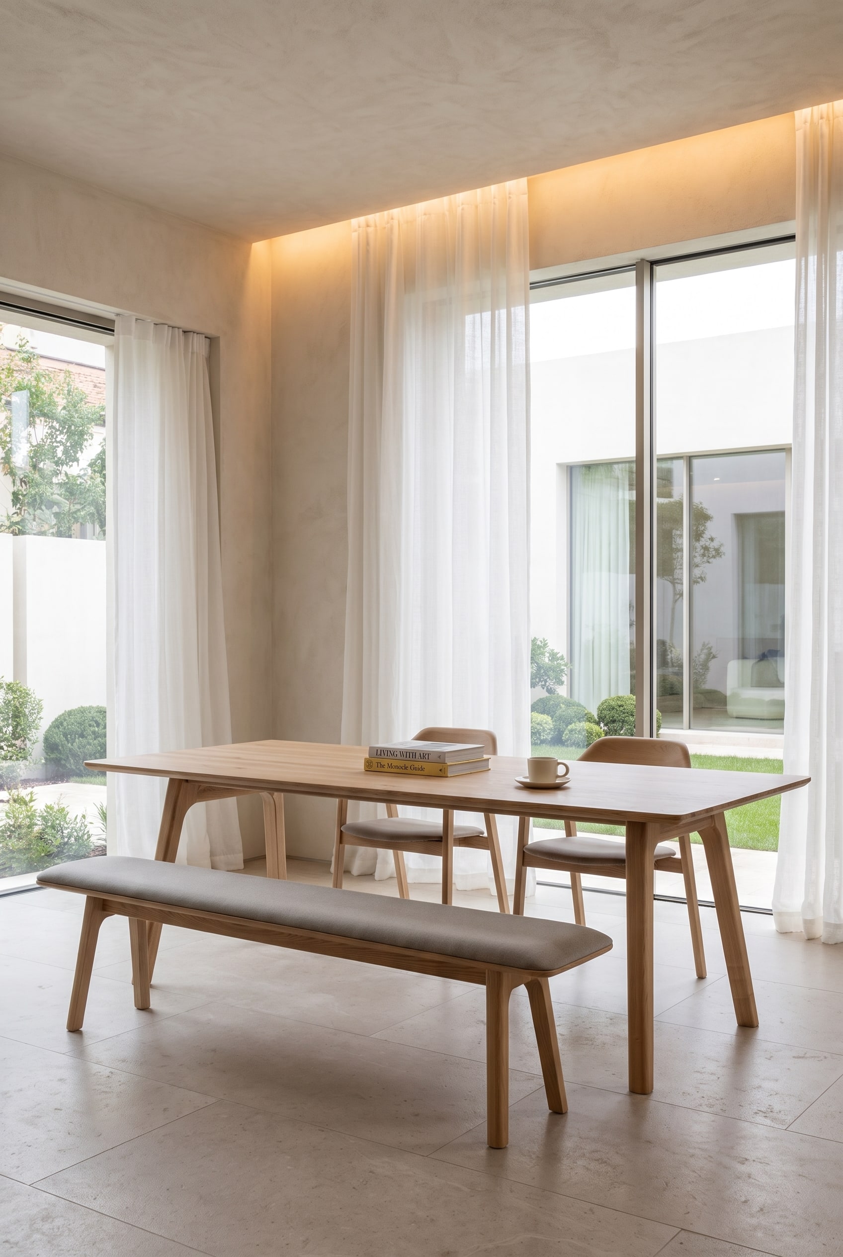 Weitl&auml;ufiges Esszimmer mit Holzesstisch, einer gepolsterten Holzsitzbank auf der einen Seite und einzelnen Esszimmerst&uuml;hlen auf der anderen Seite.