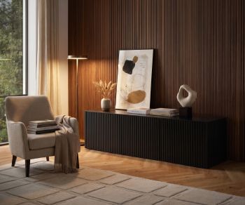 Buffet bas Punt Velasca noir comme meuble TV design dans un salon élégant avec mur en tasseaux de bois.