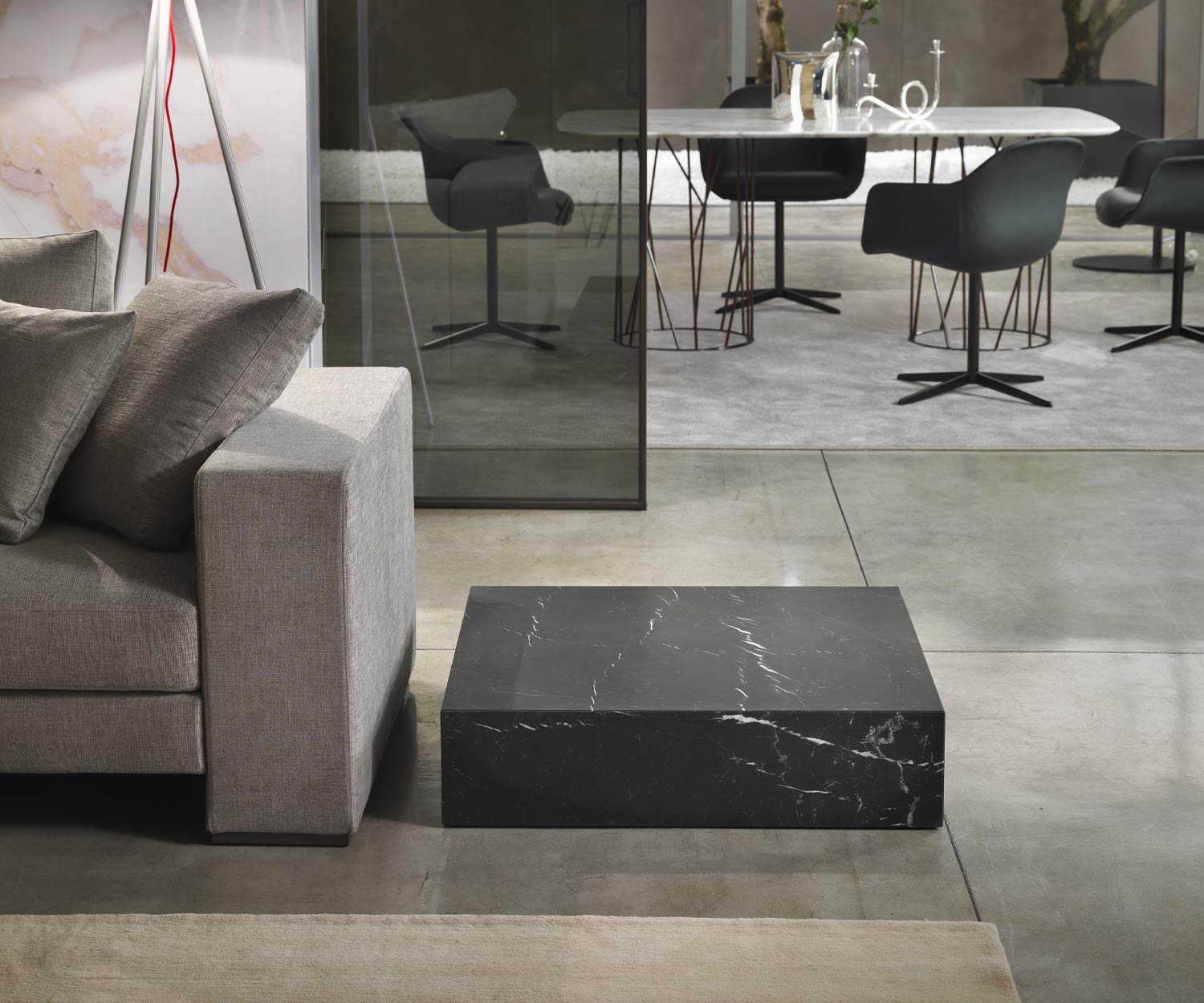 Table basse noire Thor de Marelli au sol sans socle à côté du canapé