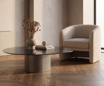 Table basse al2 dakry 006 pour salon avec plateau sombre et piètement goutte à côté d’un fauteuil en bouclé moderne
